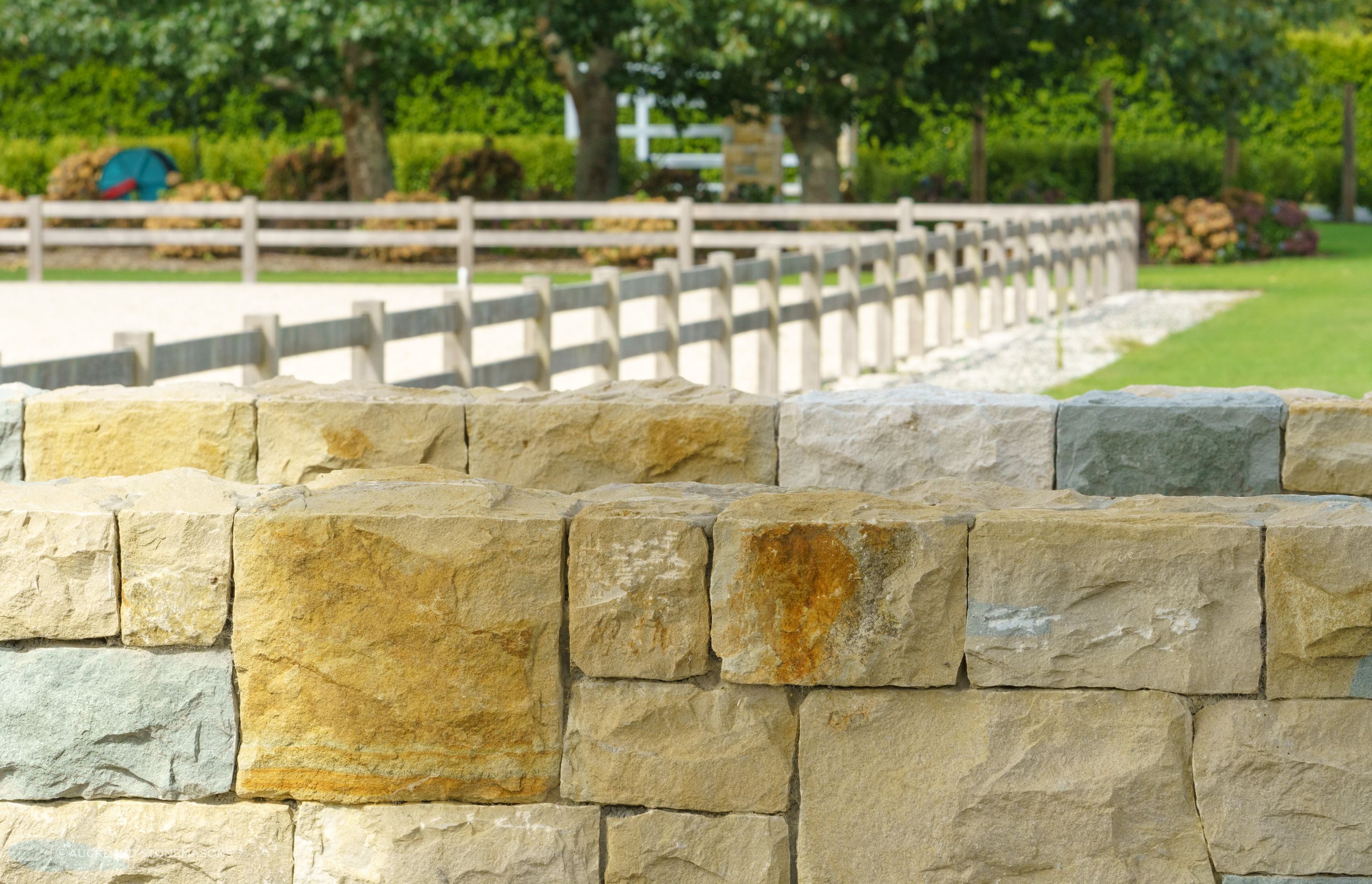 Stone boundary walls like this naturally add beautiful shades and textures to a property.