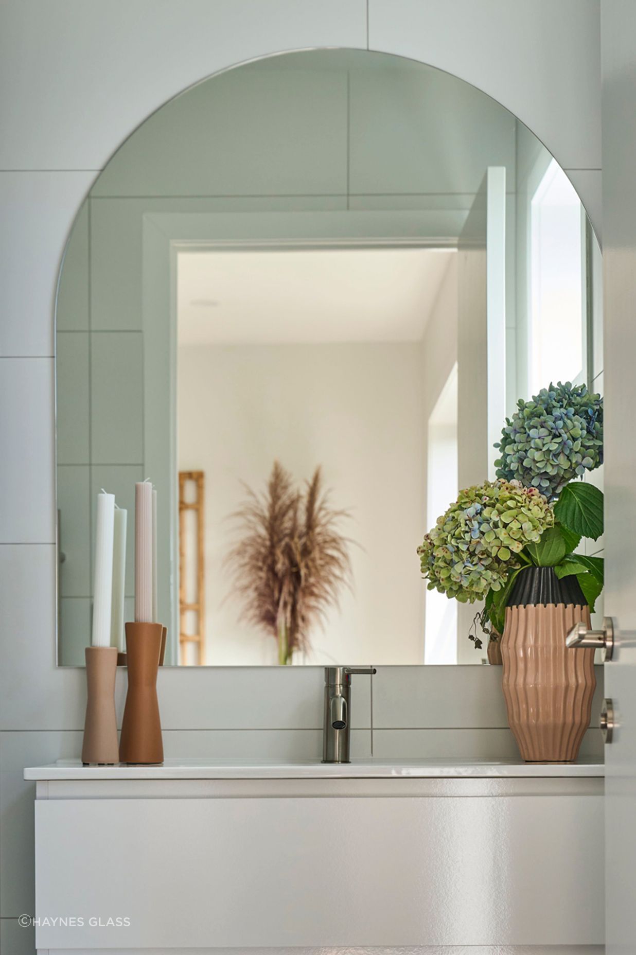 This custom arch mirror is the perfect addition to this small bathroom.