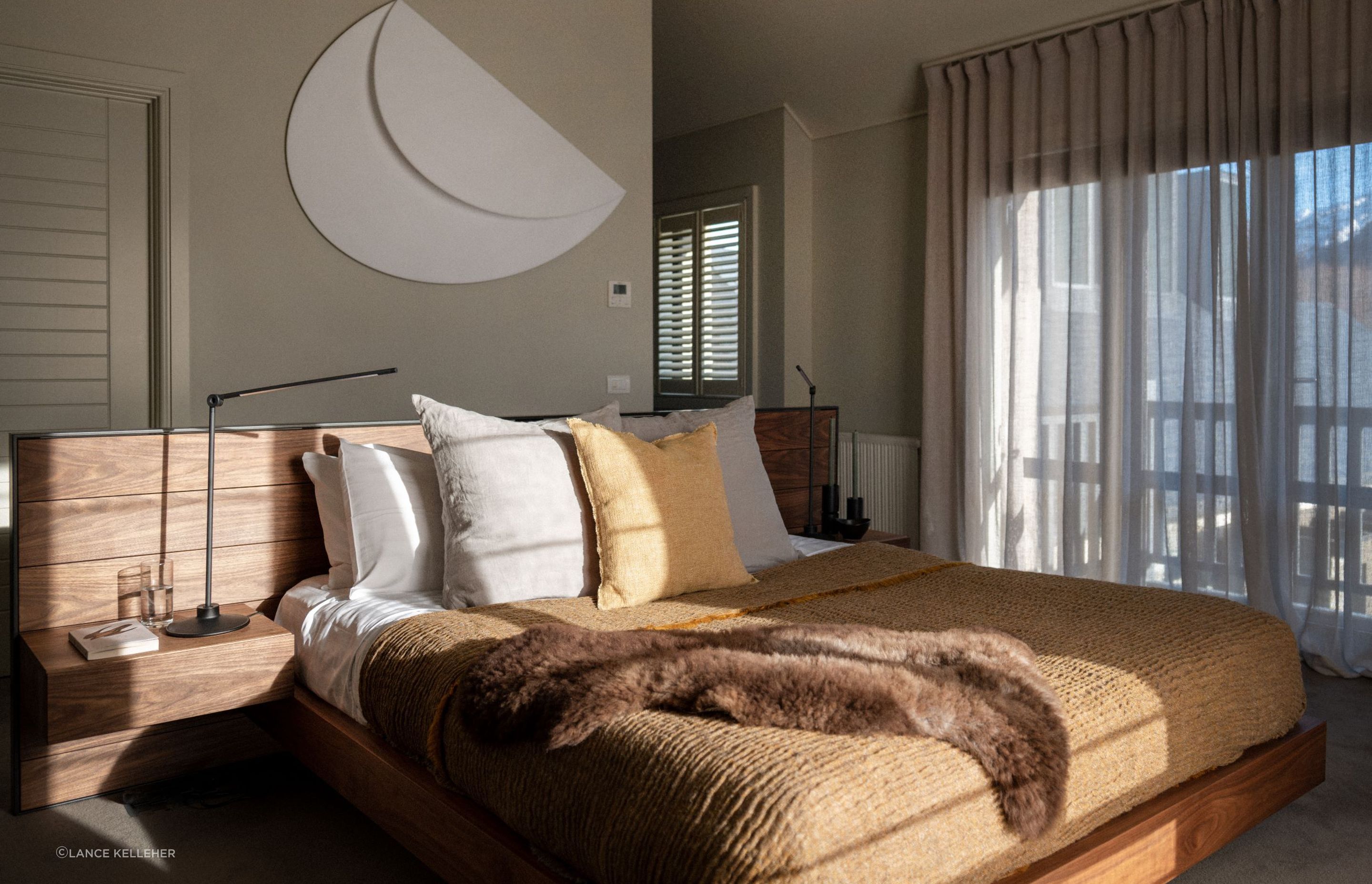 Combining textures, like the natural hardwood bed frame and soft bedding of this gorgeous South Island home, adds warmth and visual interest to a bedroom.