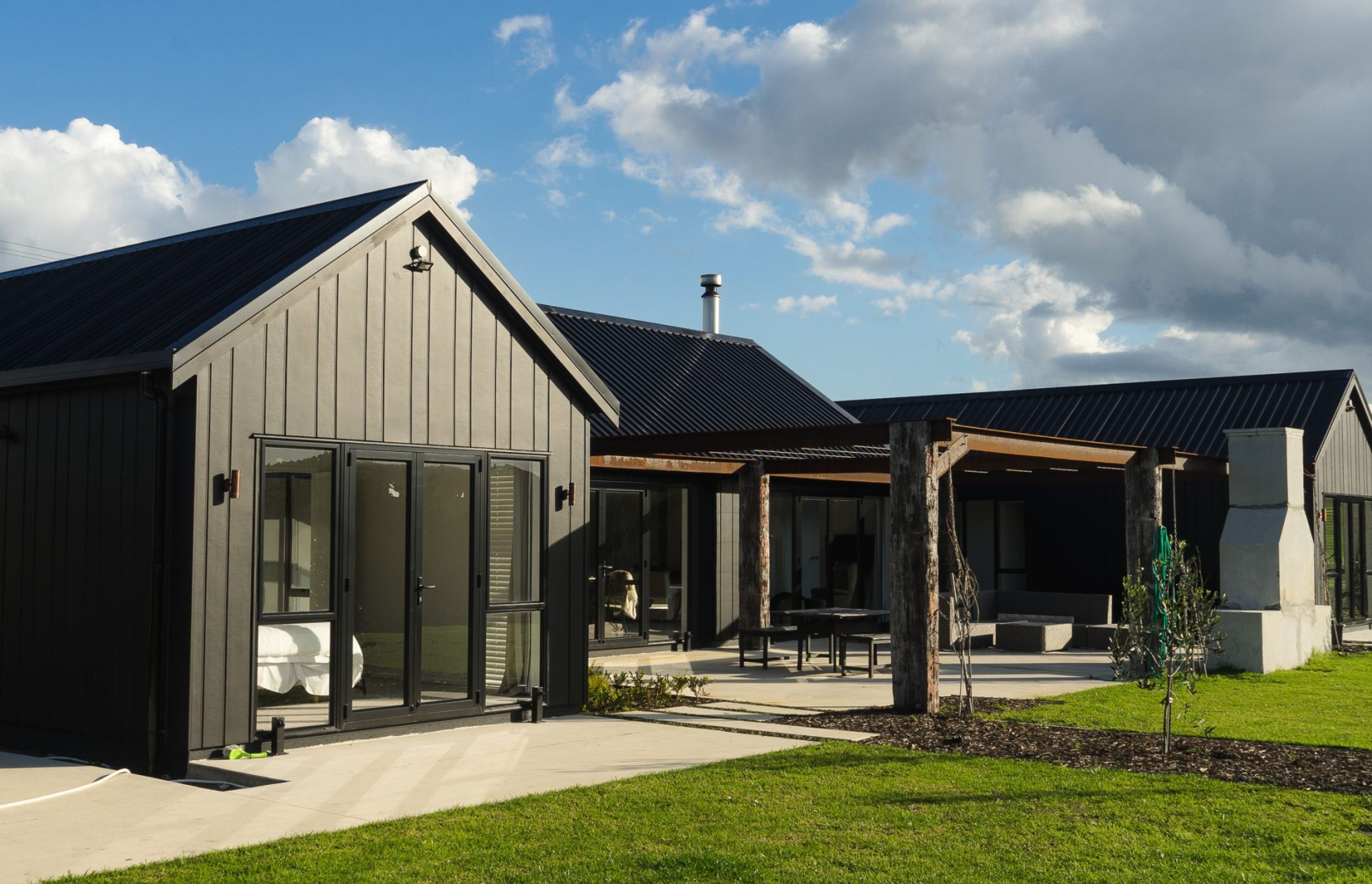 A gable roof and sleek black cladding defines this Otaika Valley home on its sprawling lifestyle block.