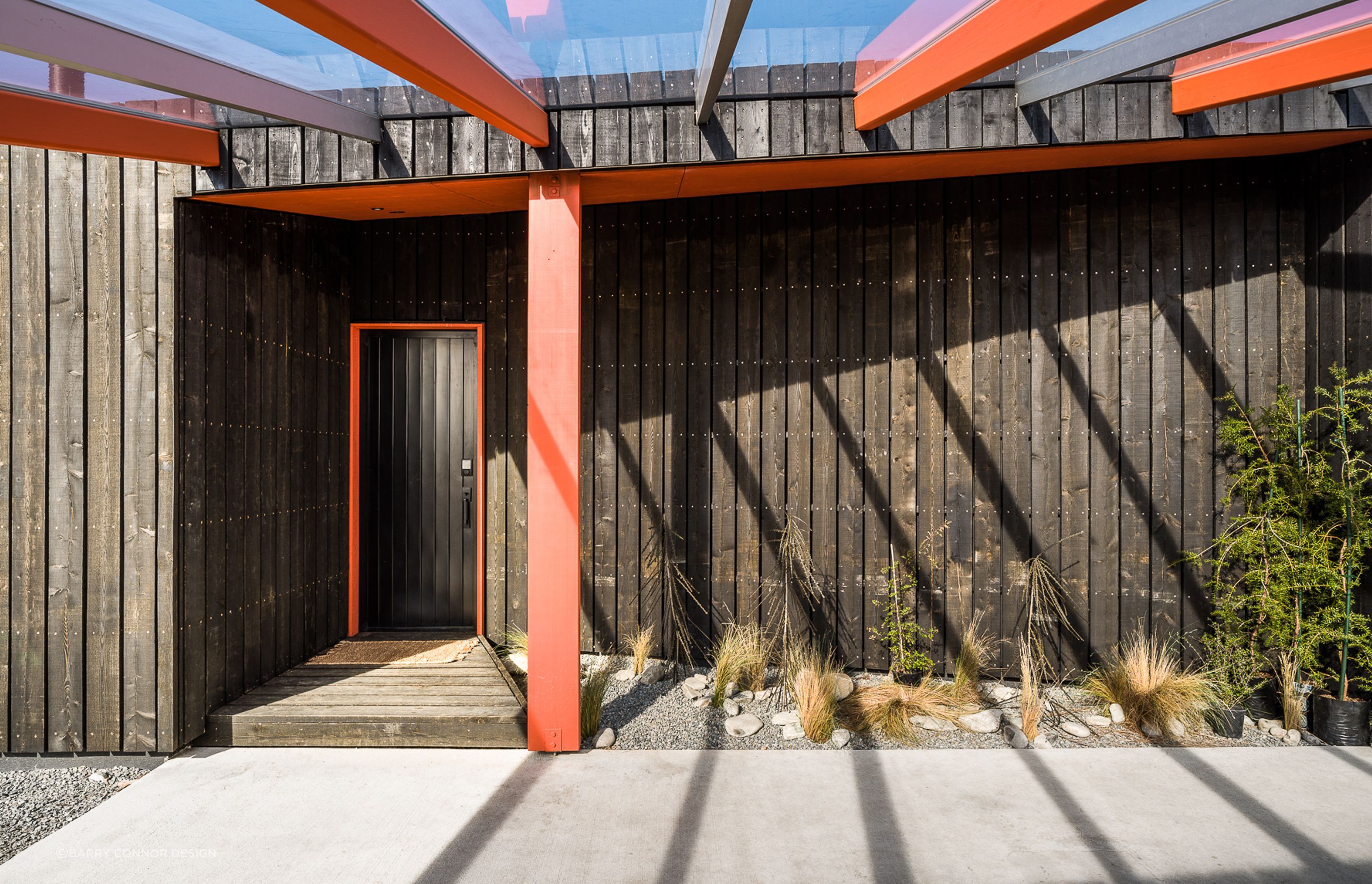 The entry door of Skylark Cabin in the Ben Ohau Range features a cohesive colour scheme with architectural elements of the home - Photography:  Lightforge Photography