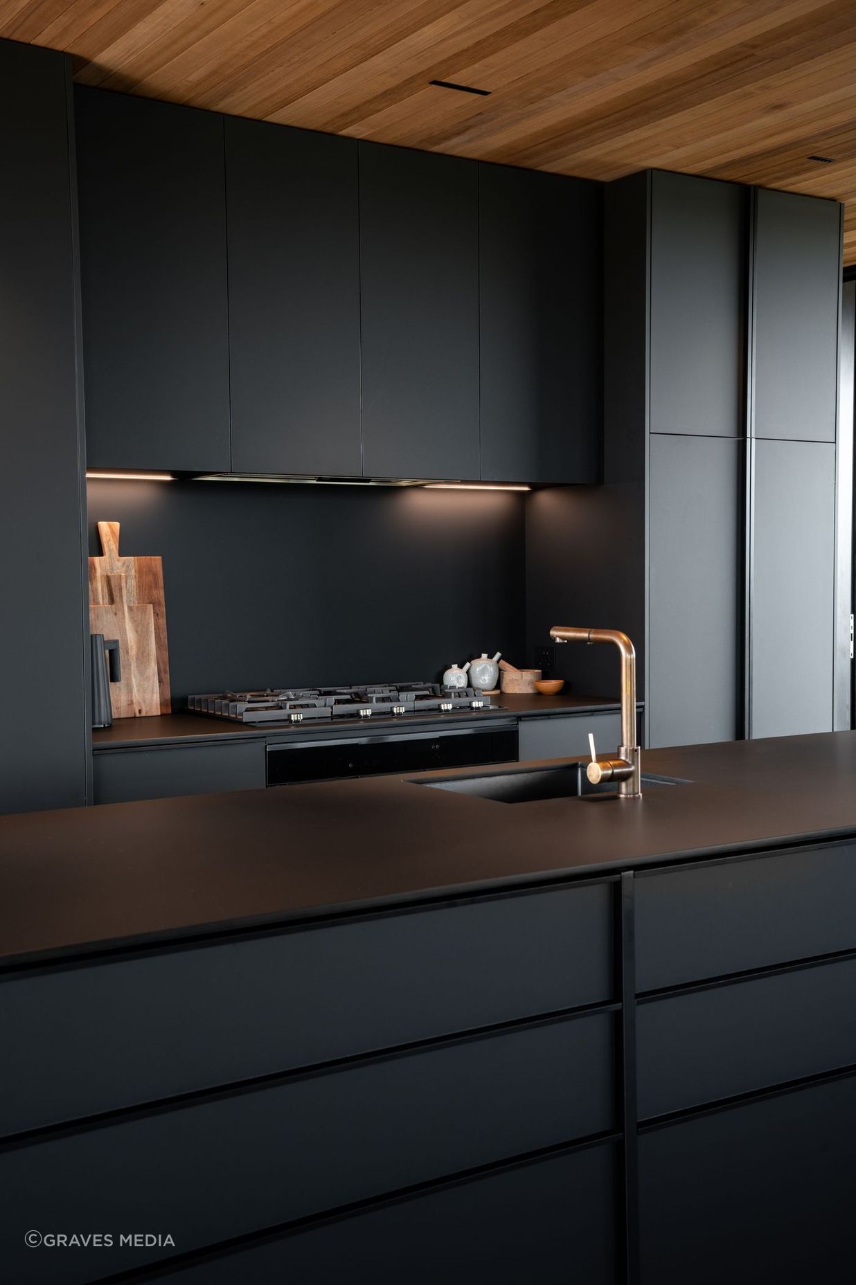 The kitchen's sleek, monotone scheme adds to the seamless aesthetic of the space.