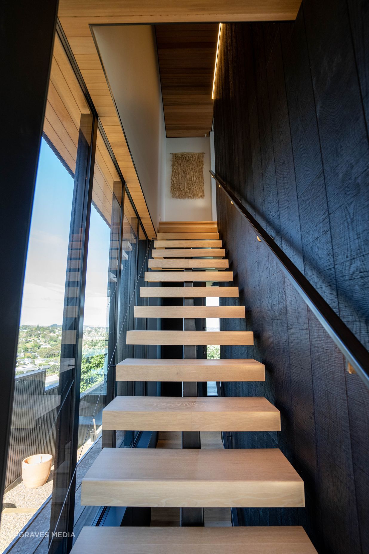 Floating oak stairs run from the basement to the master suite on the top floor.