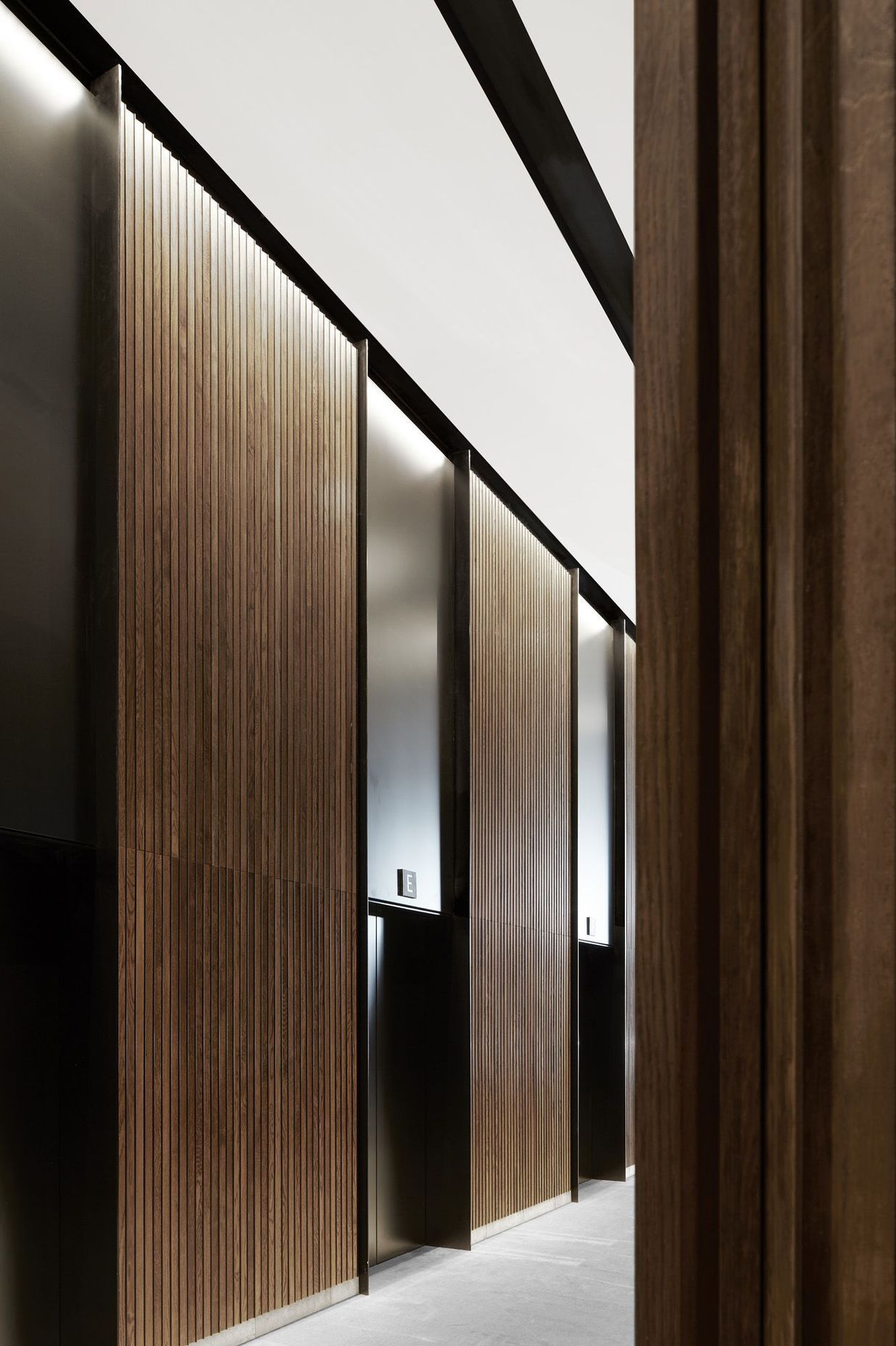 The circulation core is clad in timber panelling with black aluminium lifts.