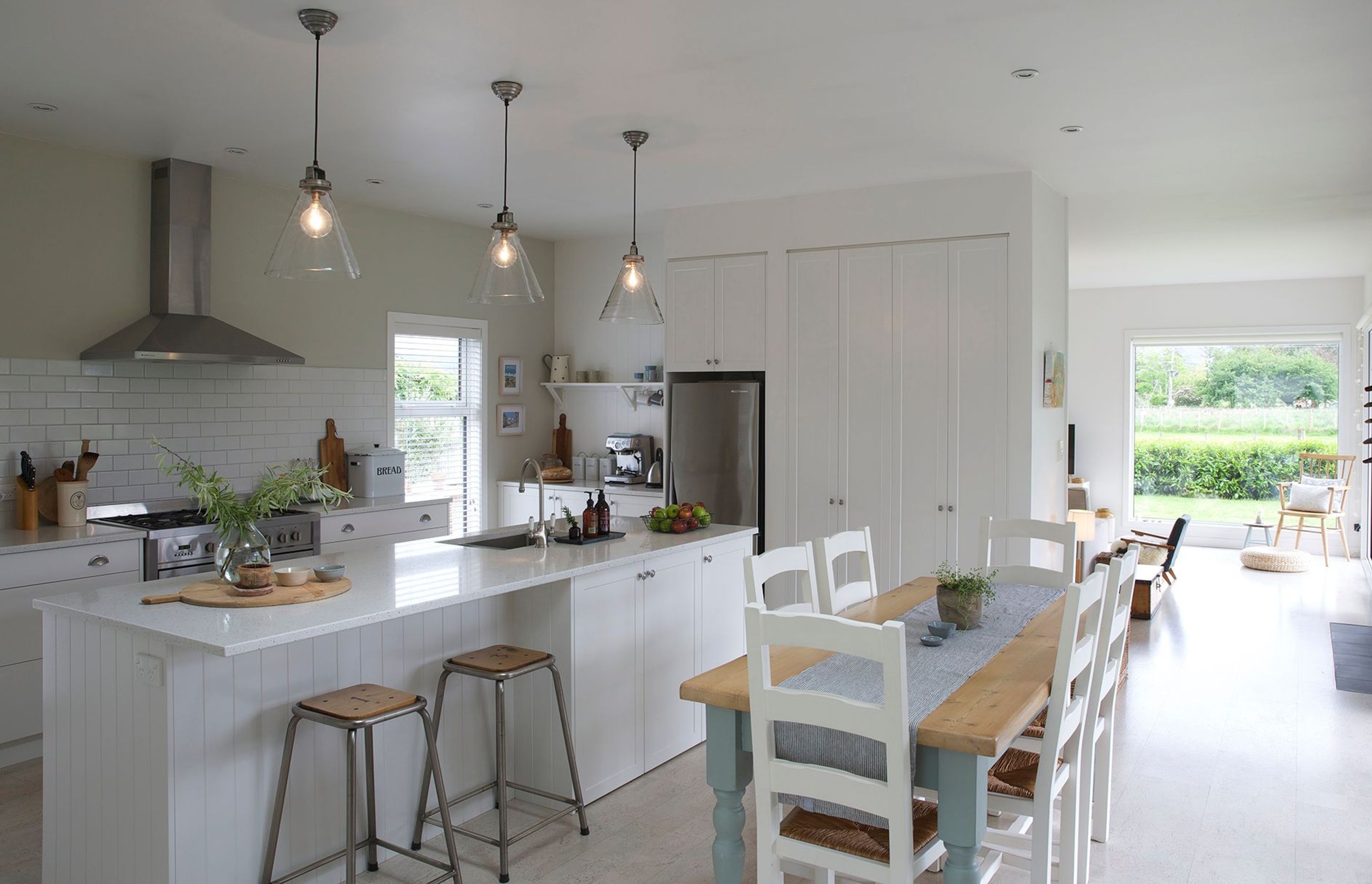 The relaxed kitchen and dining space flows through to the lounge and outdoor dining area. Light-coloured natural cork flooring provides a reflective surface to further lighten the interior.