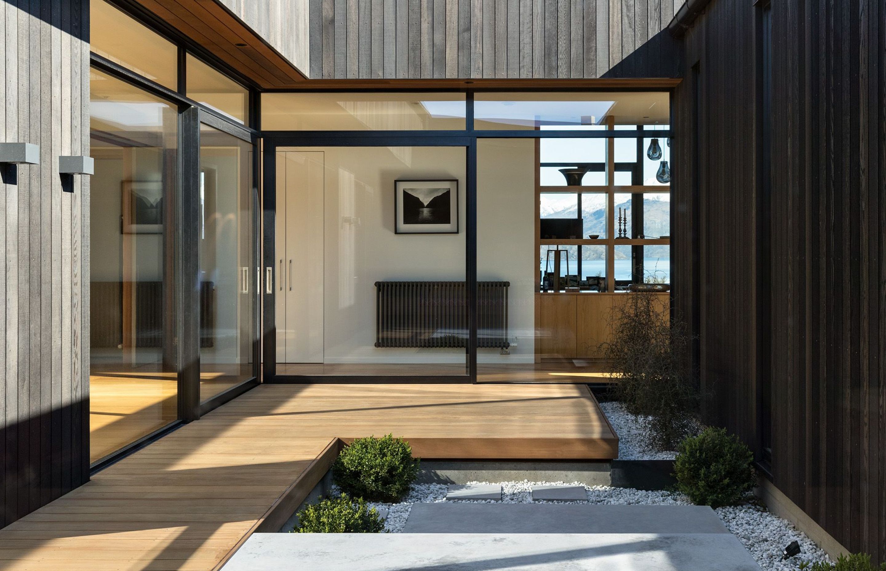 The central interior courtyard with two glass walls with corner opening doors is a light well that transforms otherwise south-facing rooms into areas bathed in sun and light. 