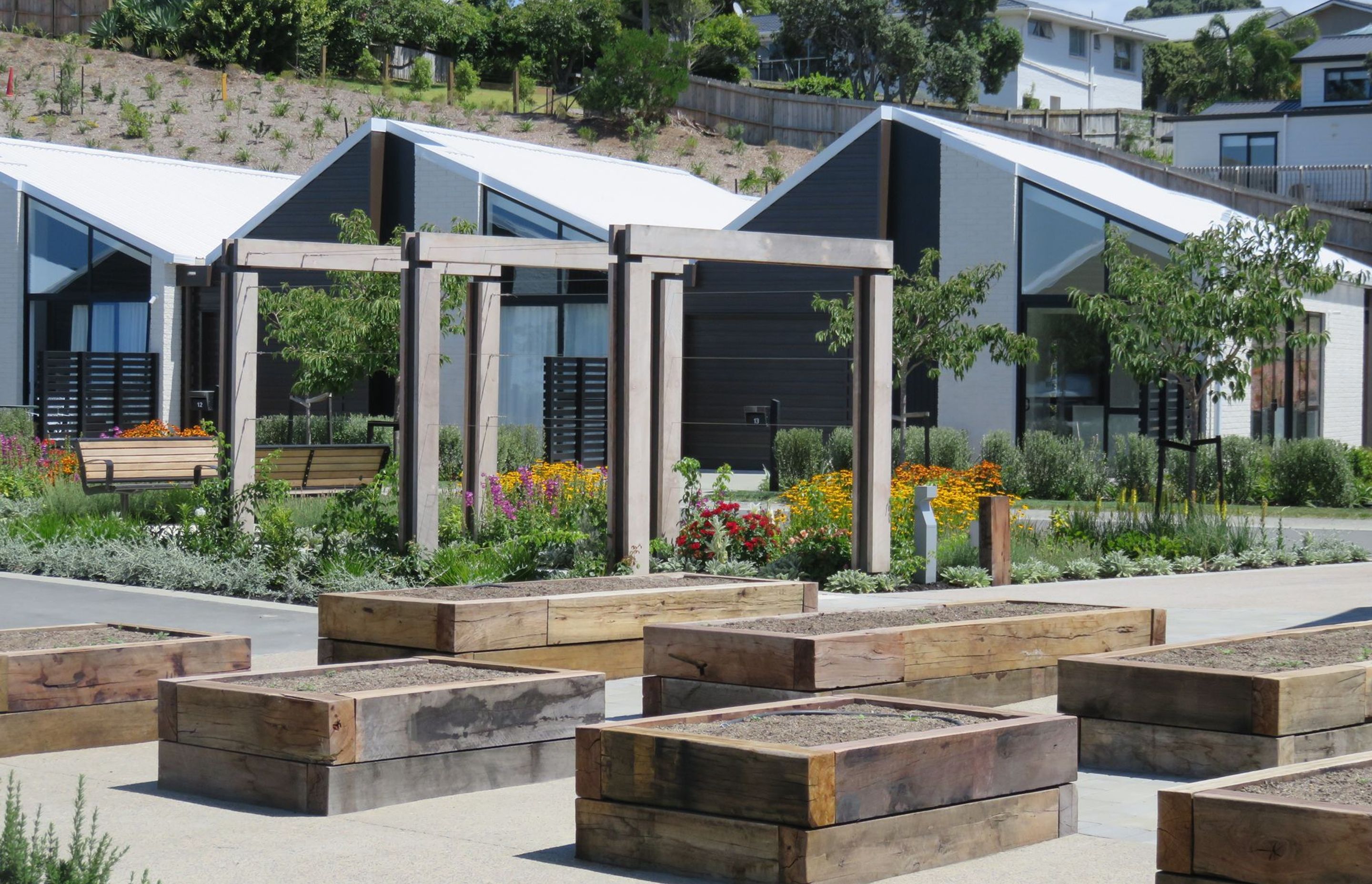A mix of landscaping types, including raised vegetable beds, provide residents with points of interaction within the landscape.