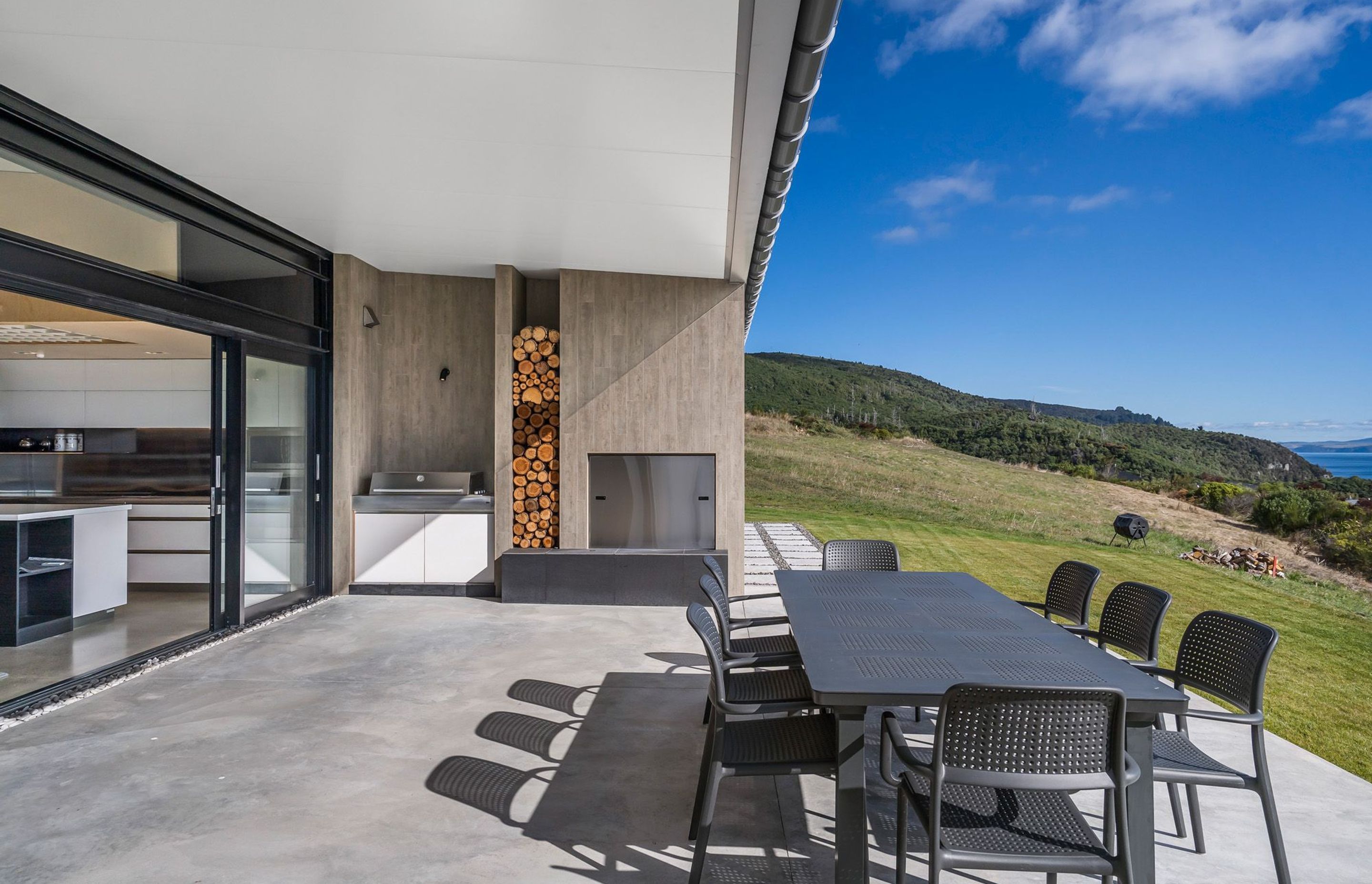 The outside kitchen, BBQ and dining area expands into lawn and overlooks Lake Taupo. Photograph: ArchiPro