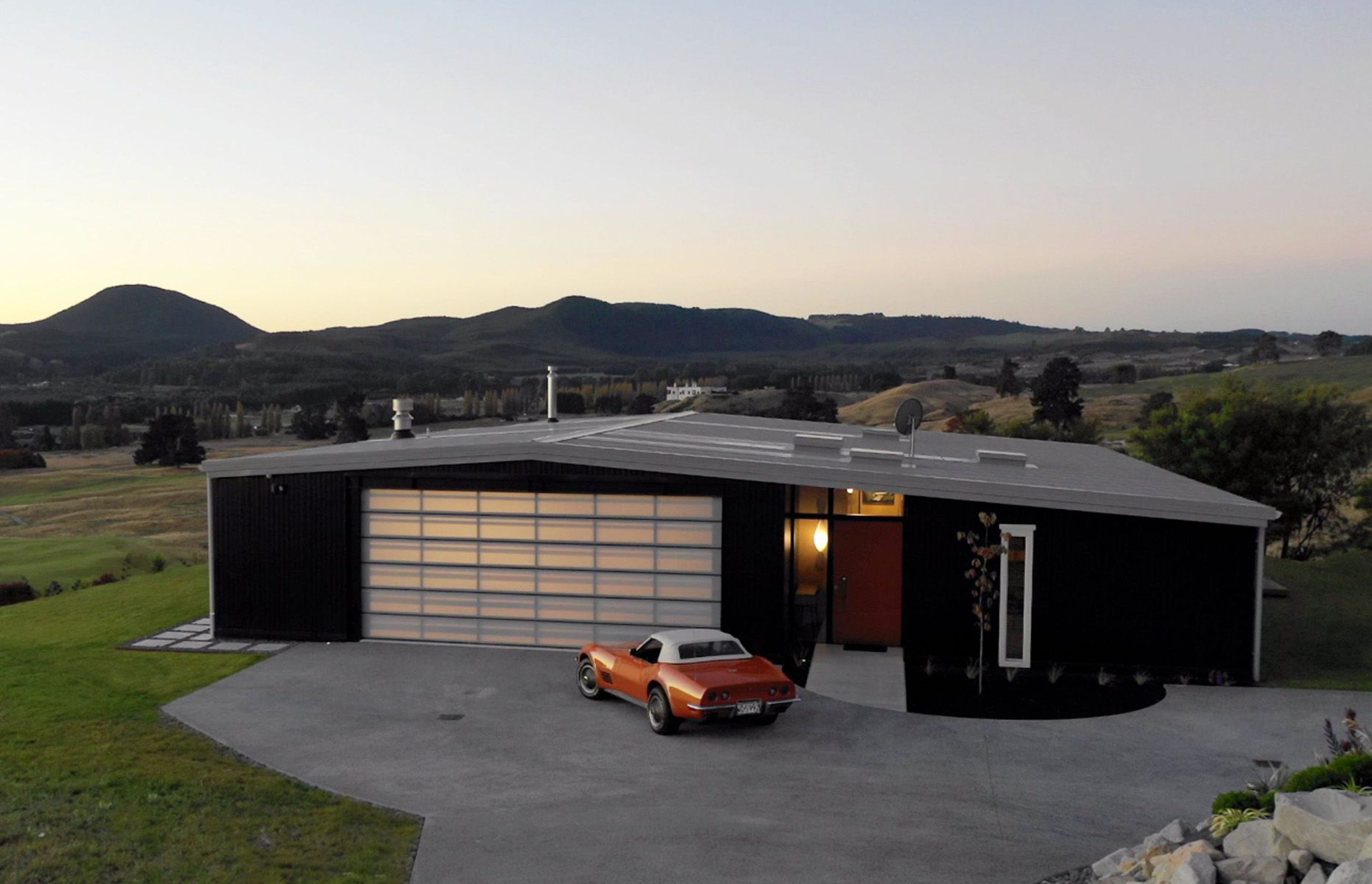 The front door of Kinloch House matches the colour of the owners' beloved Corvette, while the garage door creates a lantern effect when lit up at night. Photograph: ArchiPro.