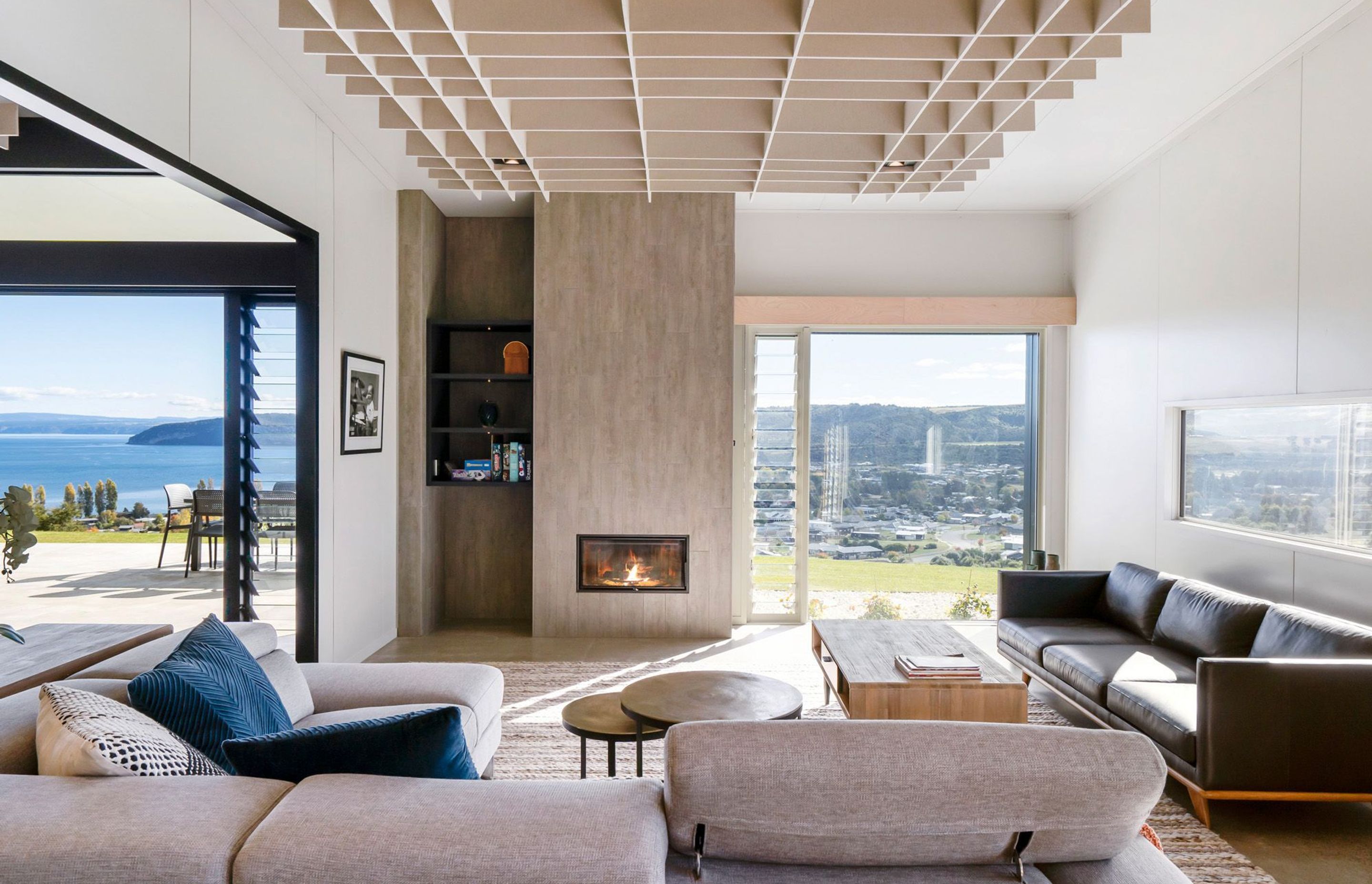 This lounge is the perfect place to relax with its roaring fire inside and floor-to-ceiling views of Lake Taupo and the surrounding landscape. Photograph: ArchiPro.