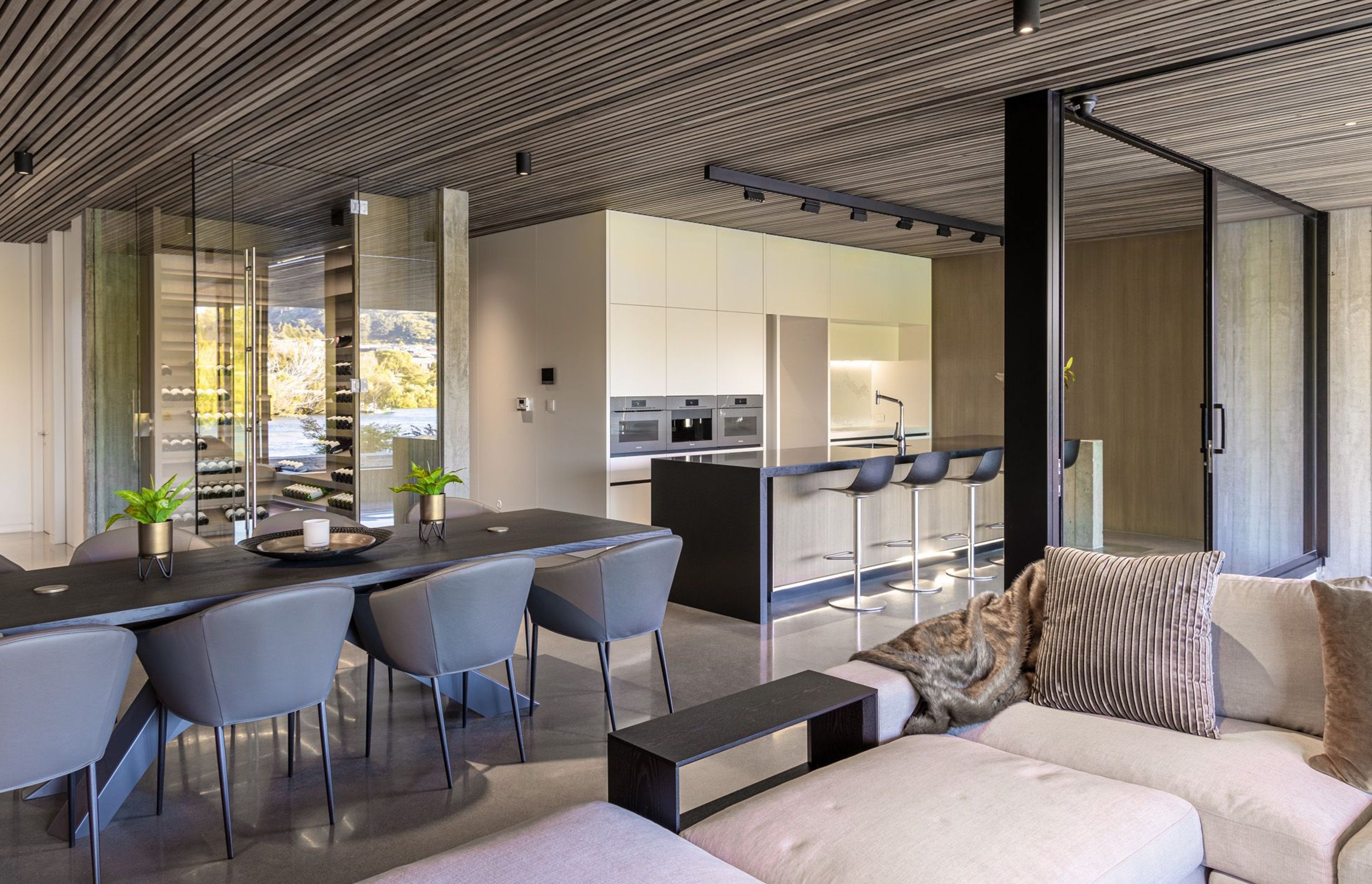 The L-shaped open-plan kitchen, living and dining area opens up into the outdoor room via large sliding doors.