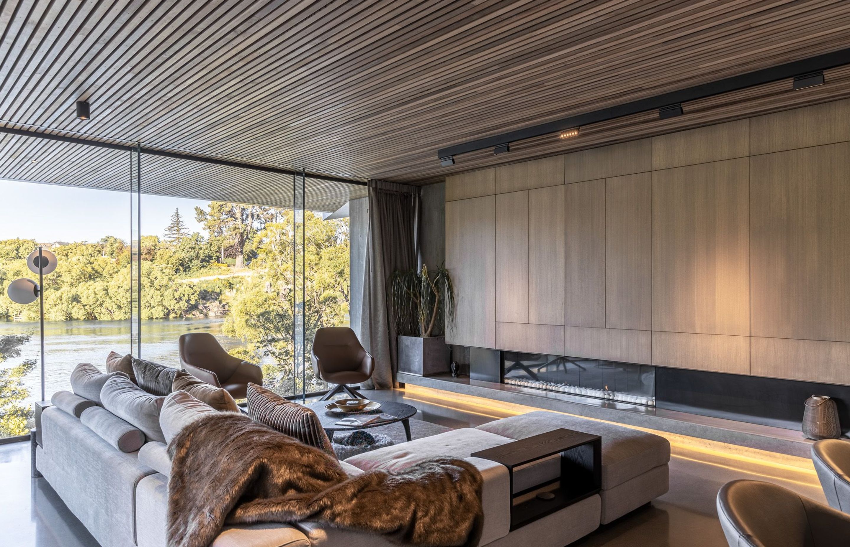 Cedar-panelled ceilings in the living spaces continue through the glass, helping to connect the inside with the stunning surrounding landscape.