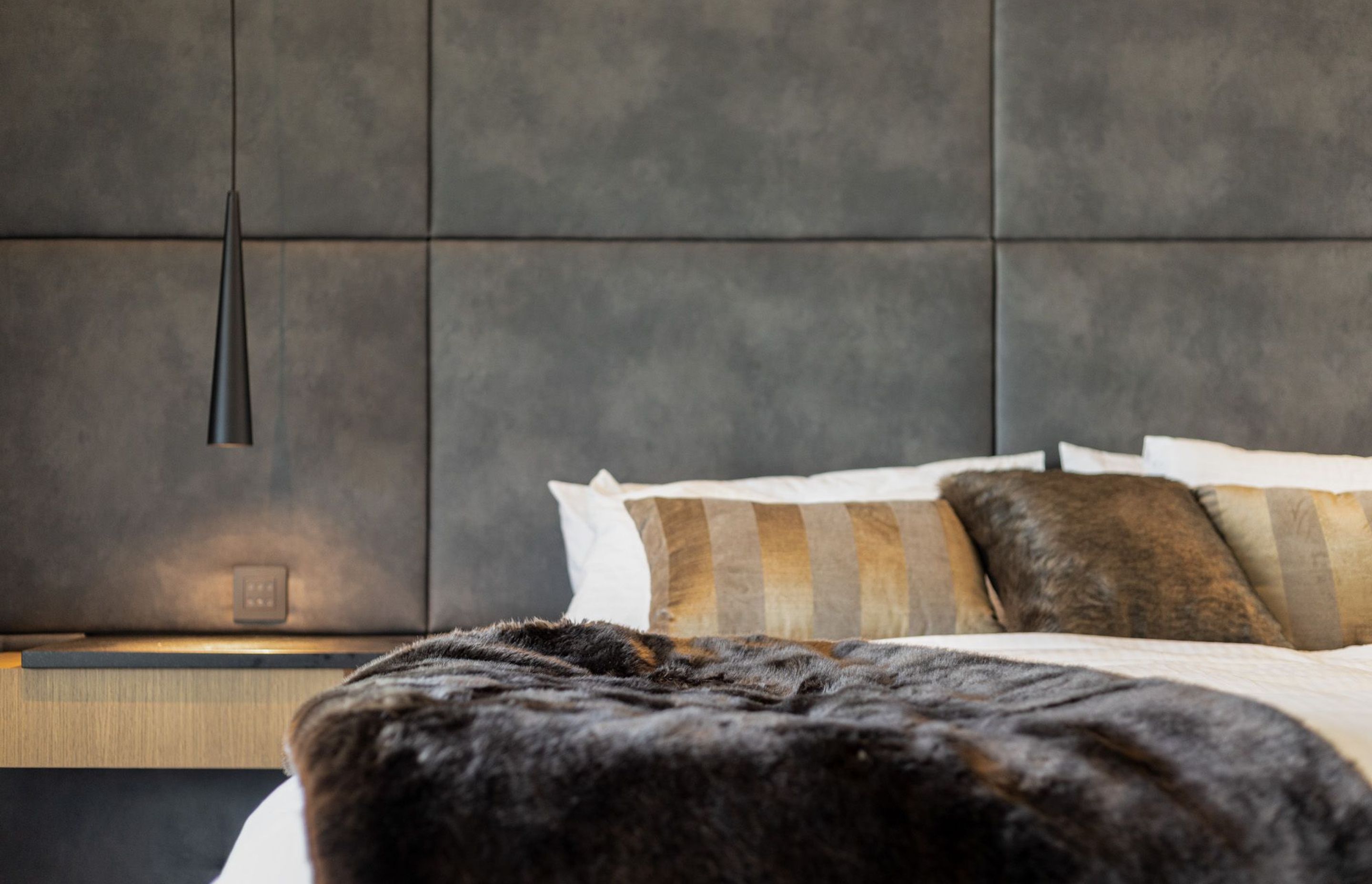 The luxe bedroom adopts neutral colours placed tone on tone with plenty of different textures.