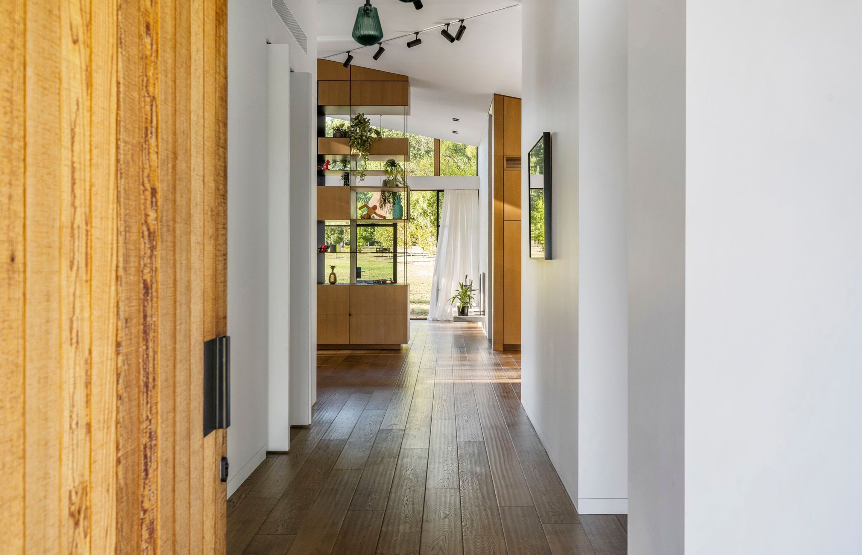 From the cedar front door, the view culminates in lush greenery at the other end of the house.
