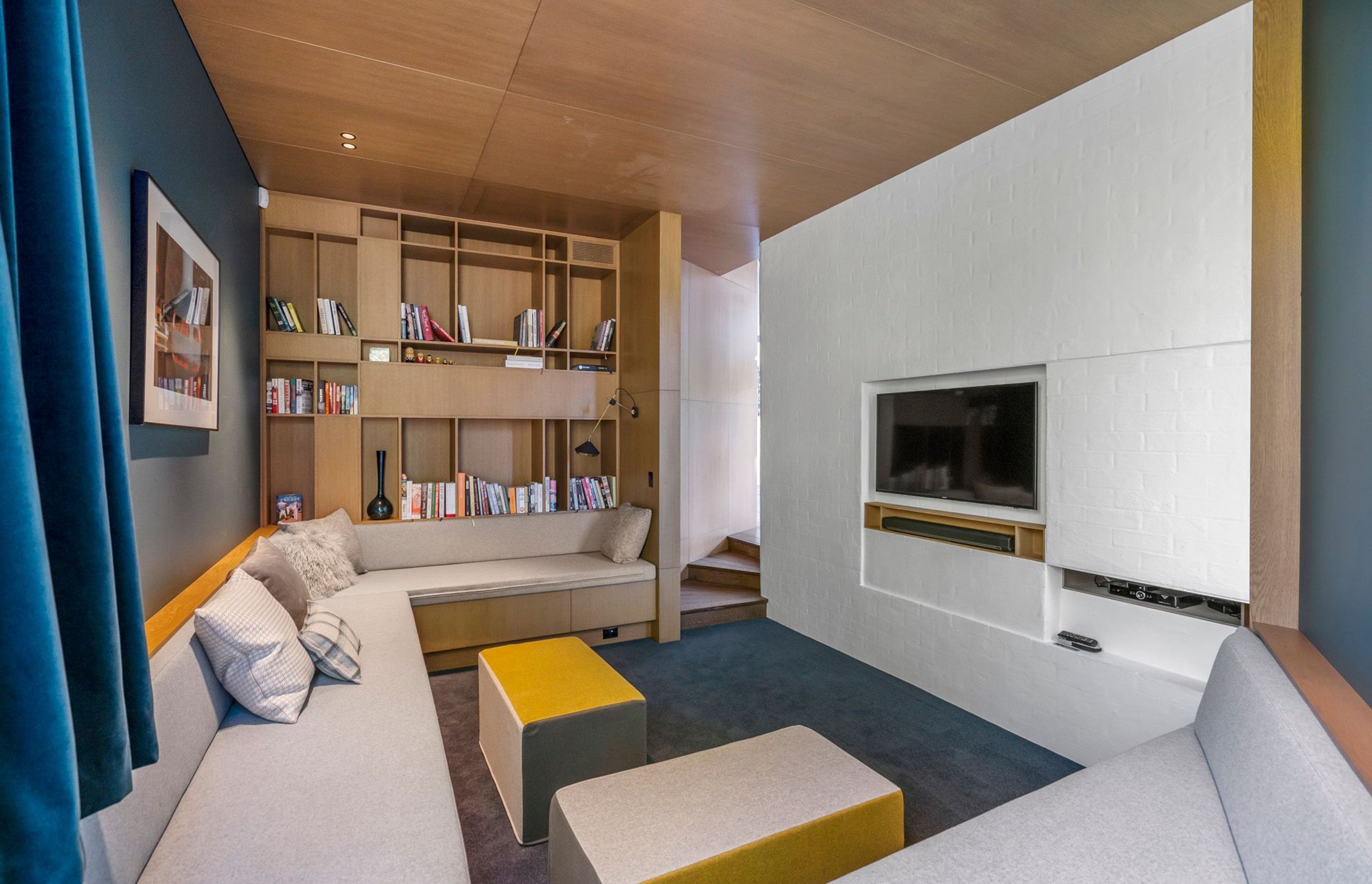The snug acts as a media room, a library and a space for the children to make dens out of the cushions from the bench-style seating that lines three walls of the space.