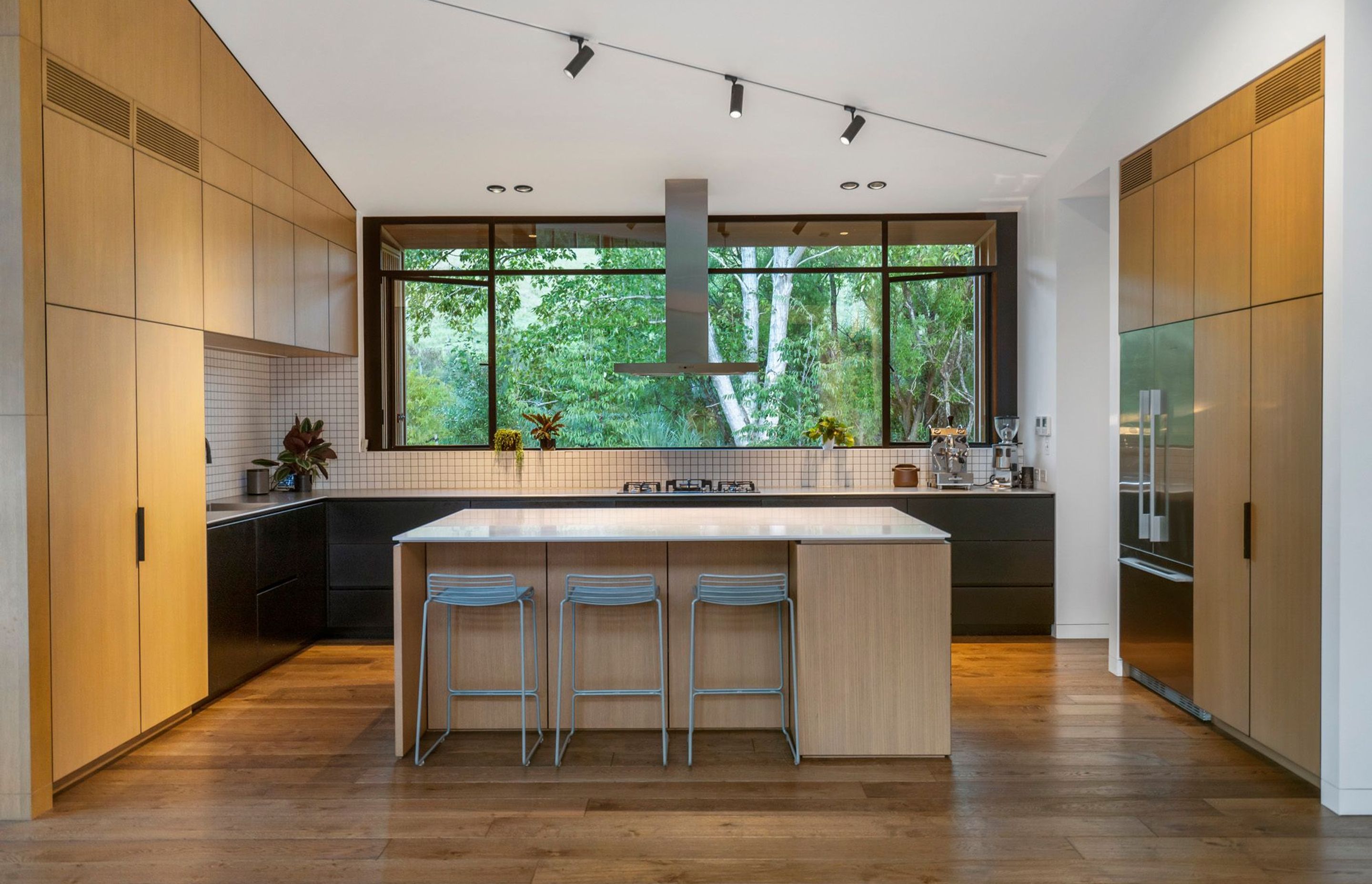 The kitchen is a chef's dream, with a stunning framed view of the trees, plenty of workspace and easy-to-clean surfaces.