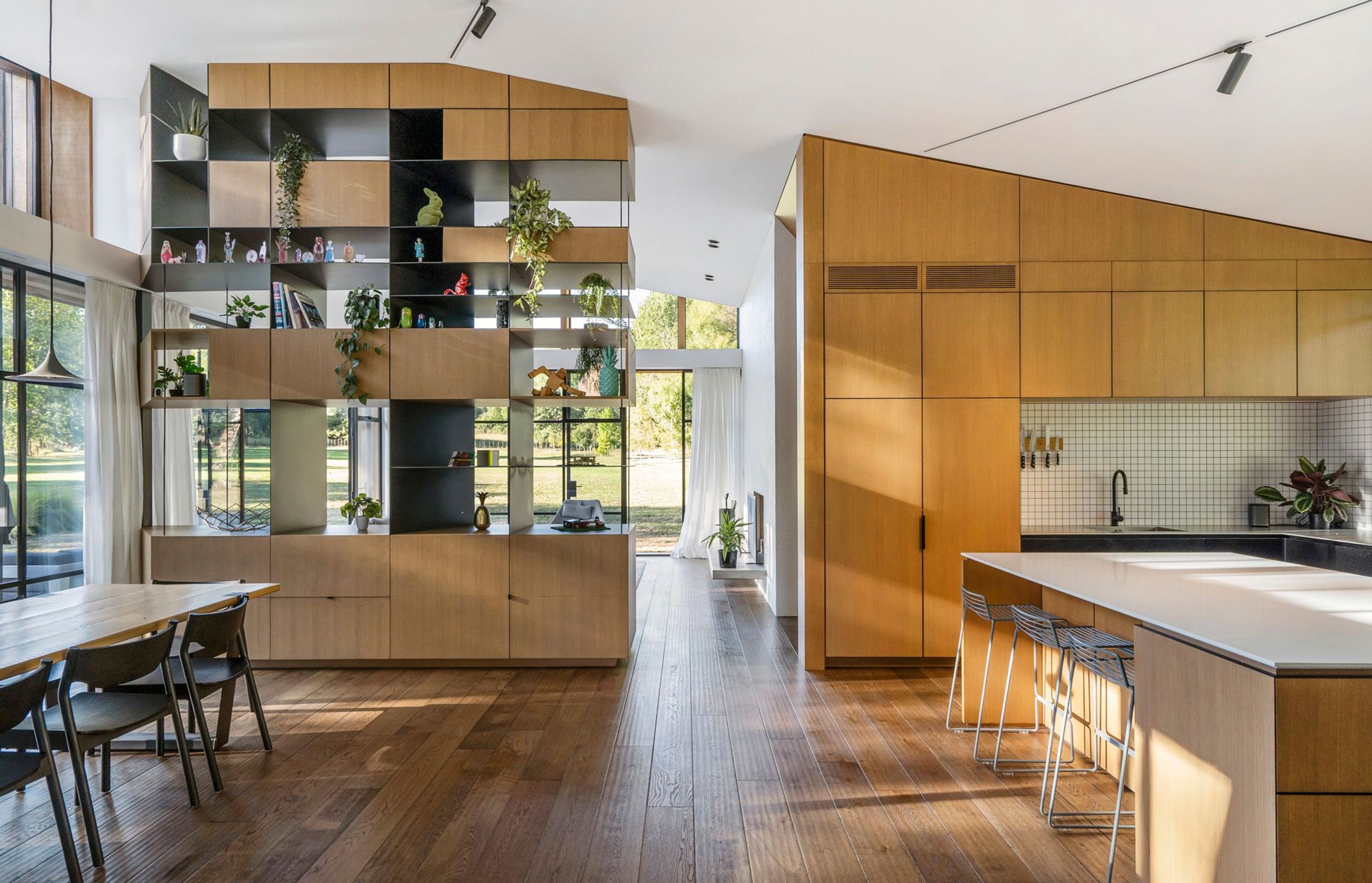 High ceilings, a quirky roof line and industrial elements, like the steel folding doors, are balanced by the warmth of natural timbers – seen in the oak flooring and cabinetry.