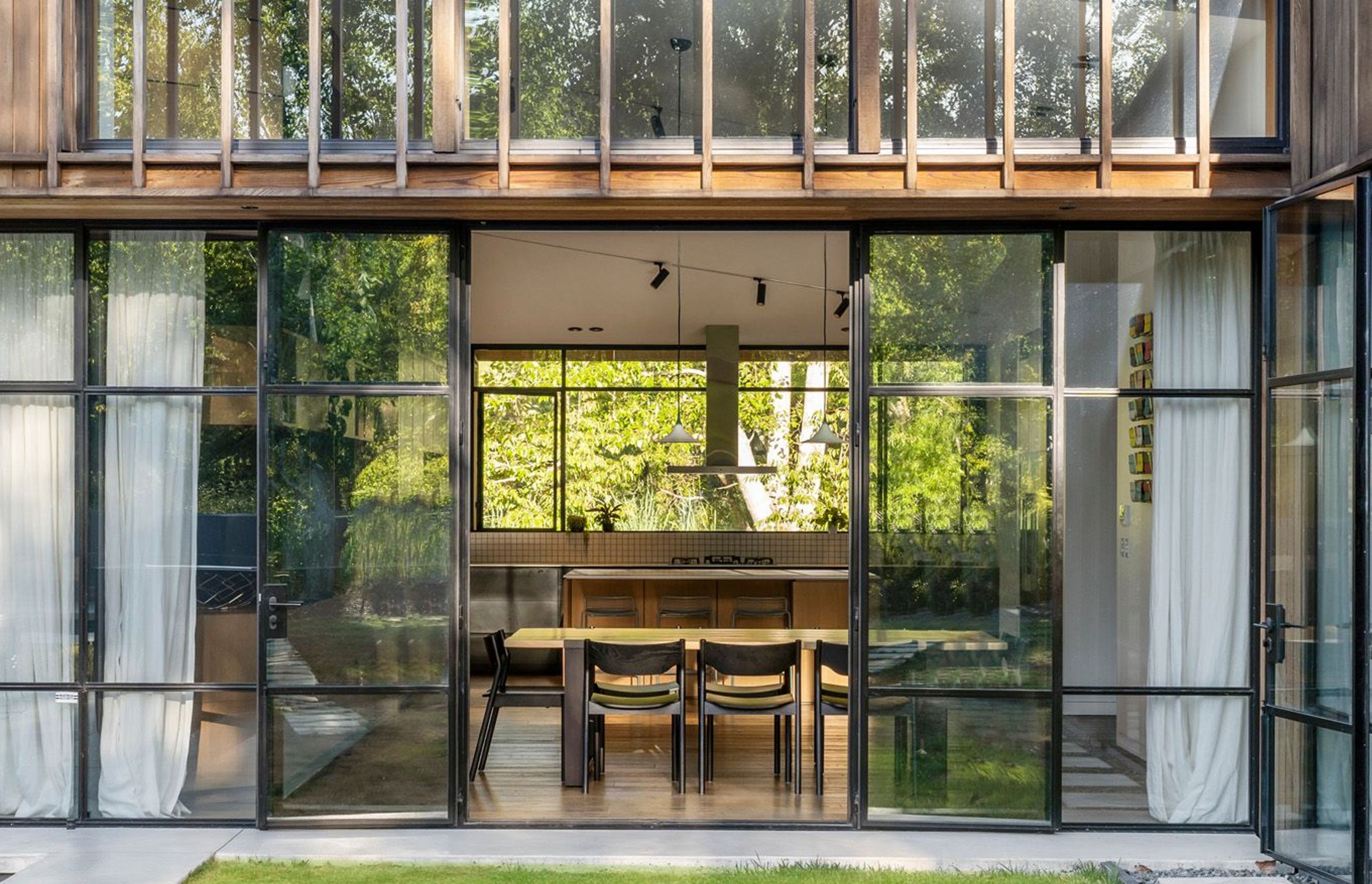 Enter the dining and kitchen area through full-height folding steel doors.