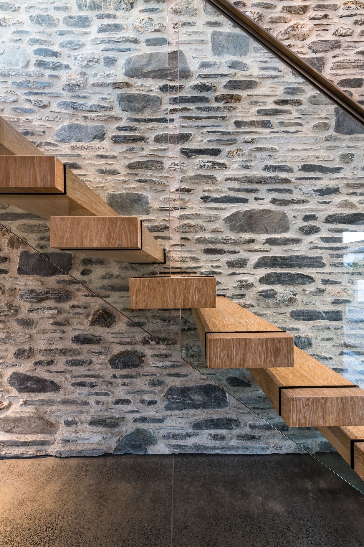 American oak stair treads add warmth against the stone and concrete.