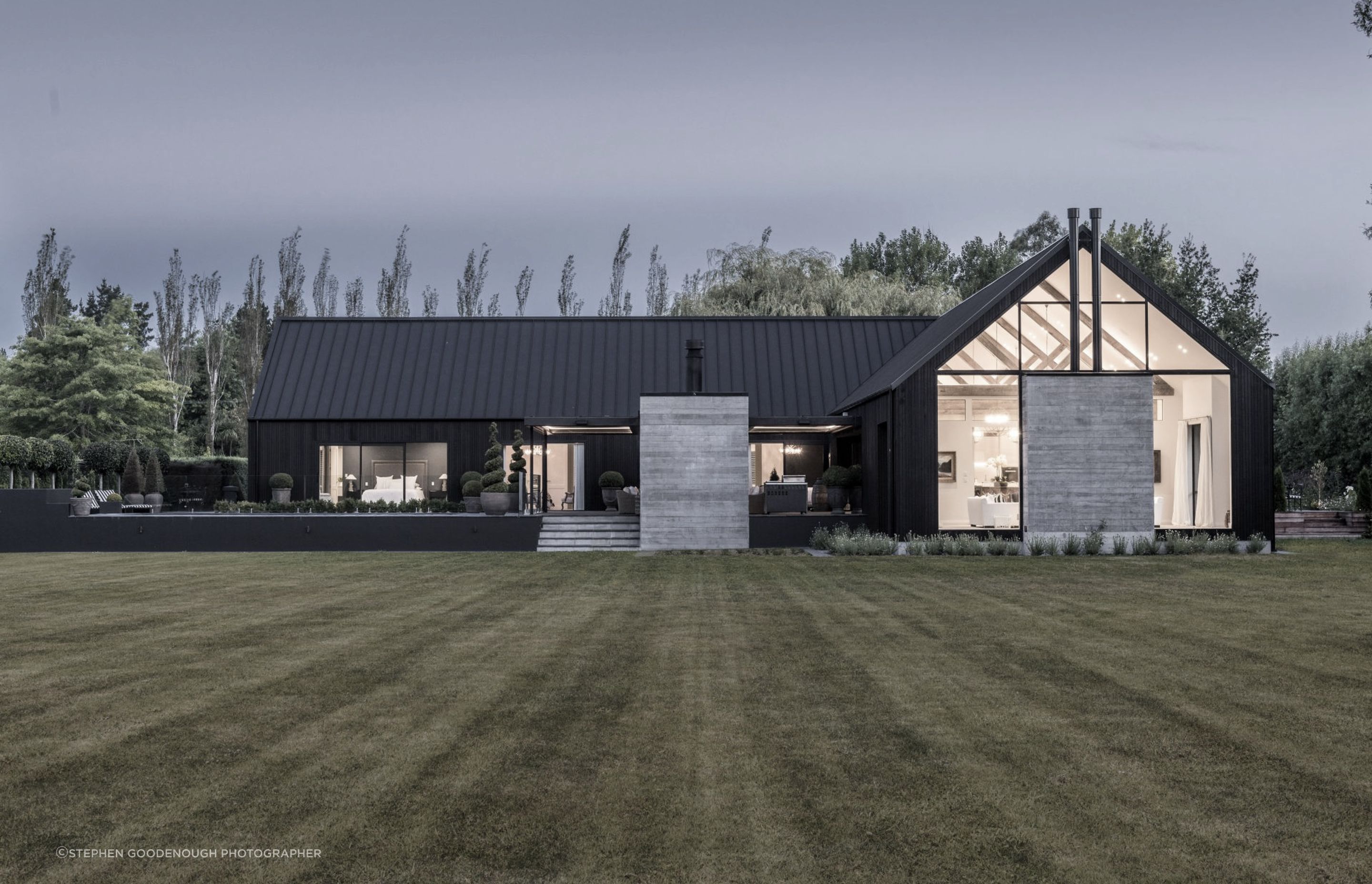 At night-time, the front elevation really showcases the monochromatic nature of this contemporary rural home.