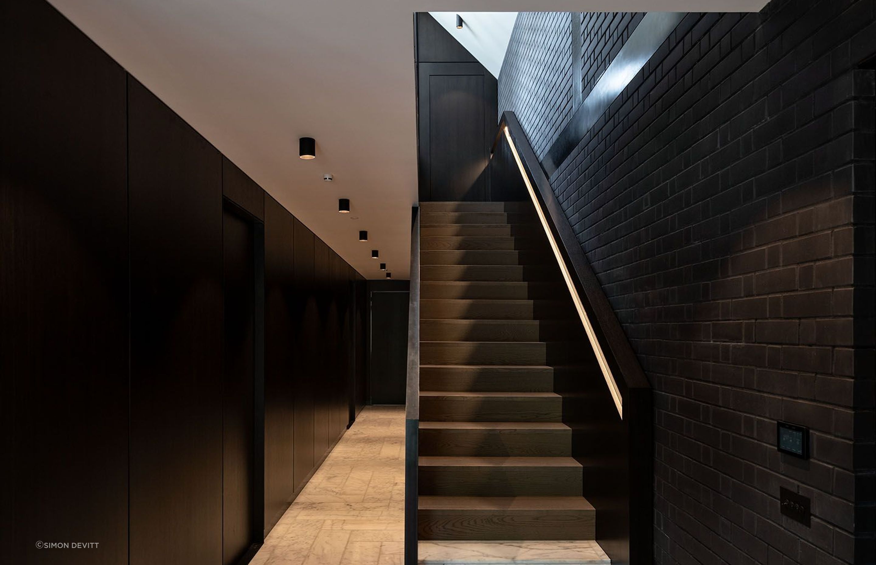 This corridor acts as the spine of the home - a spacious area that gives little away aside from an offering of texture and juxtaposition of colour.