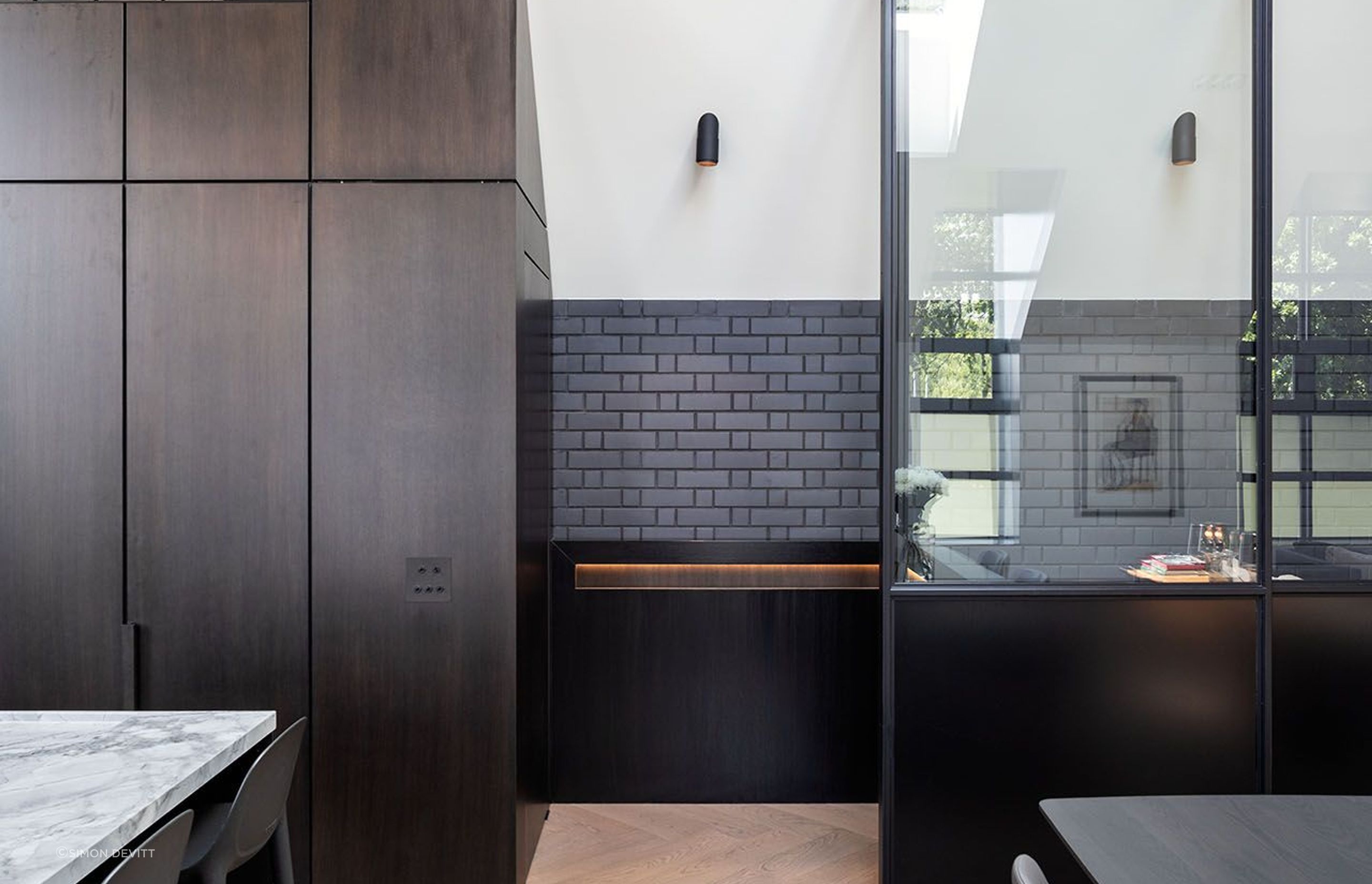 Black brick and steel are a key feature throughout the home, with the kitchen made up of two simple islands.