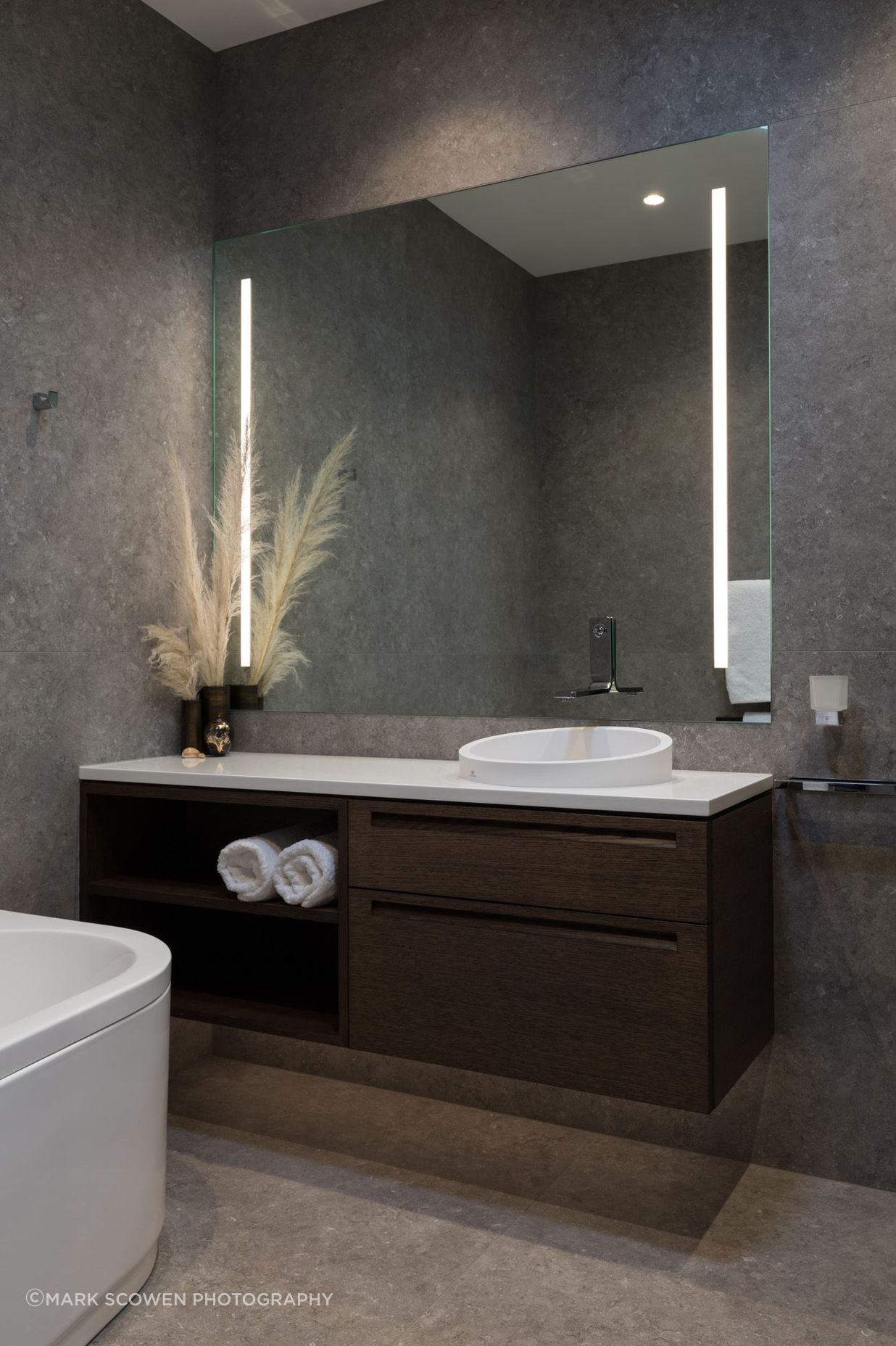 Natural tones fill this bathroom accented by built-in LED strip lights.