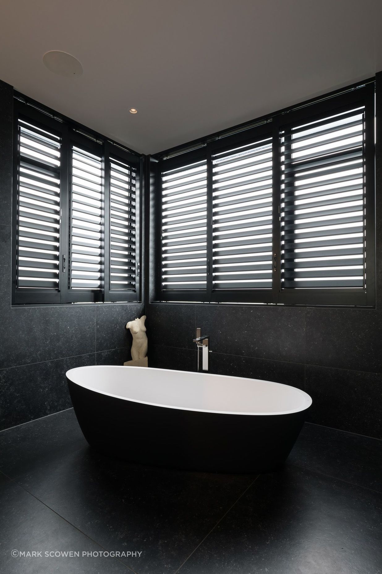 The dramatic black and white bathroom features large-format tiles.