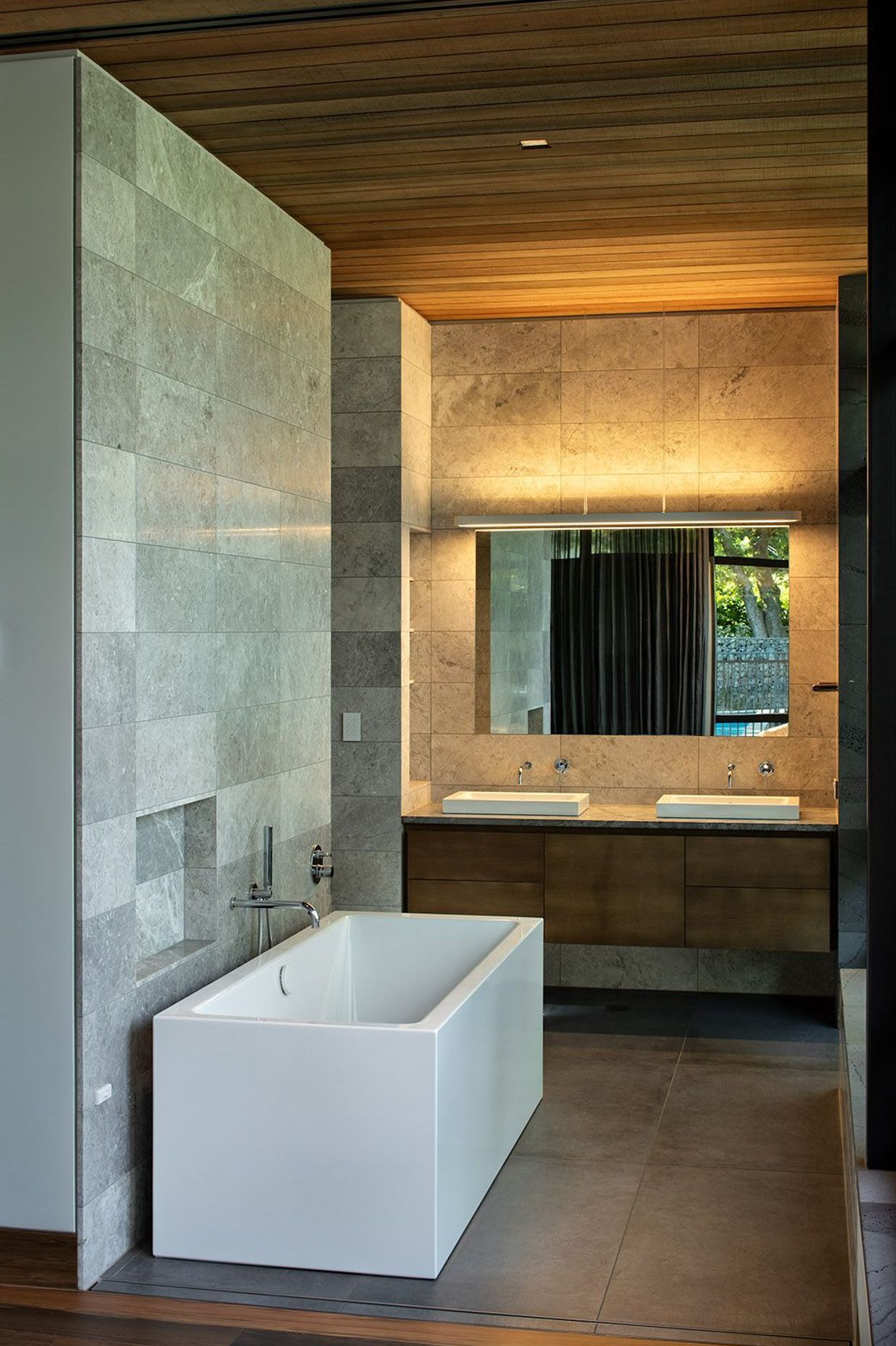 The bathrooms are lined in stone and timber to complement the rest of the house.