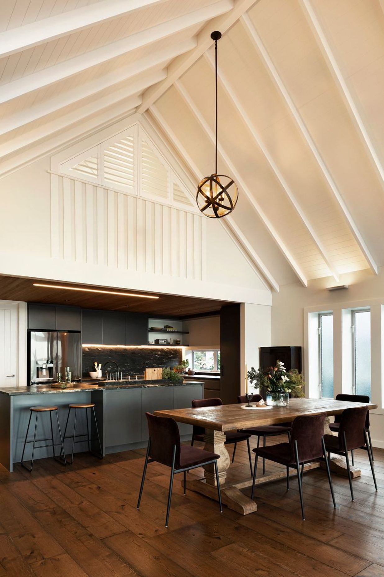 The darker palette of the kitchen, along with the lower ceiling height, allows it to recede into the space, once again directing people's attentions towards the views.