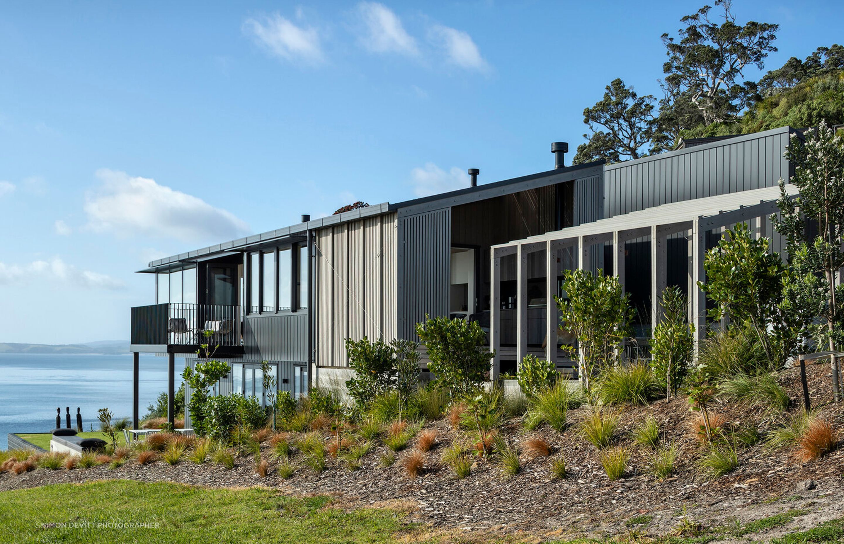 Located on an elevated section overlooking Daniels Reef north of Auckland, this new house enjoys enjoys extensive sea views across to Little Barrier Island.