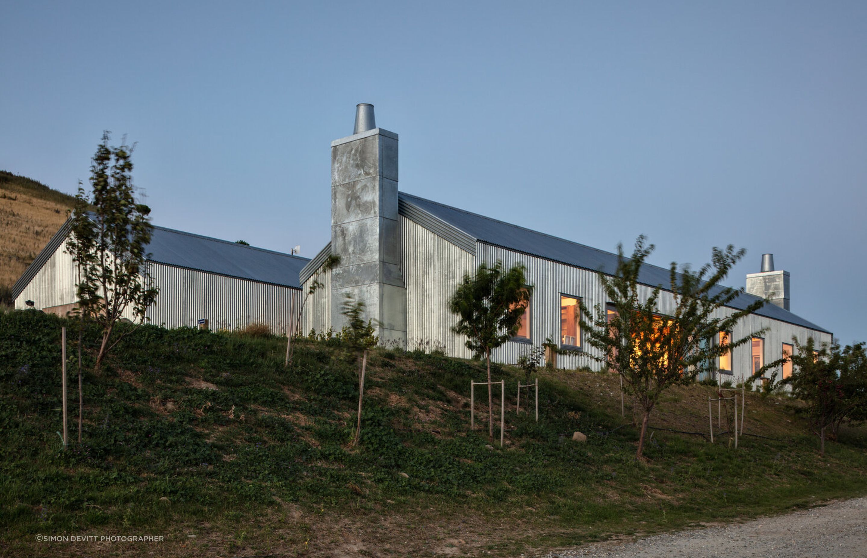 At each end of the wine-tasting building sits a fireplace with a chimney wrapped in acid-washed sheet iron.