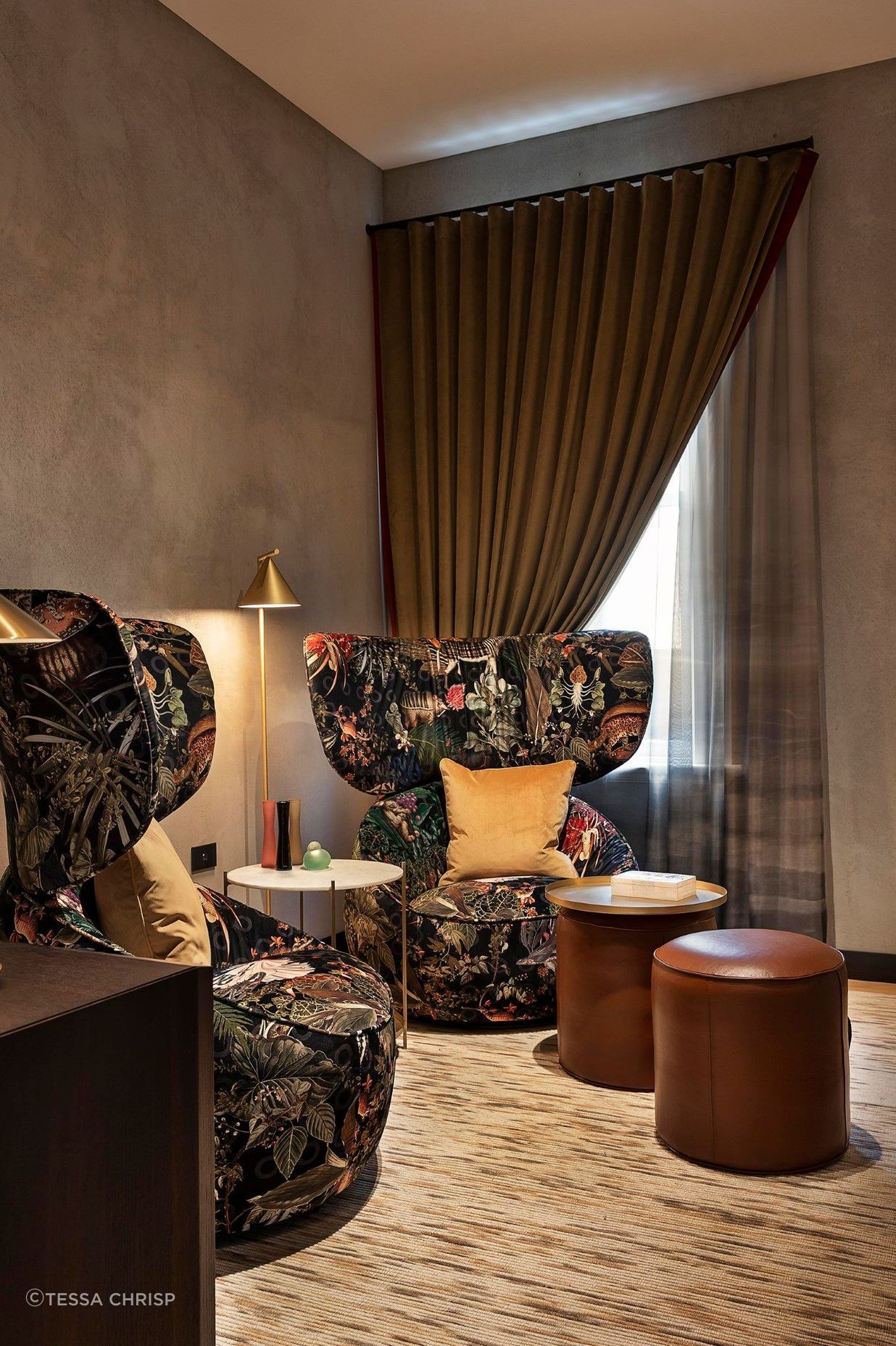 The waiting room features oversized Moooi chairs and leather ottomans for a relaxed and warm reception.