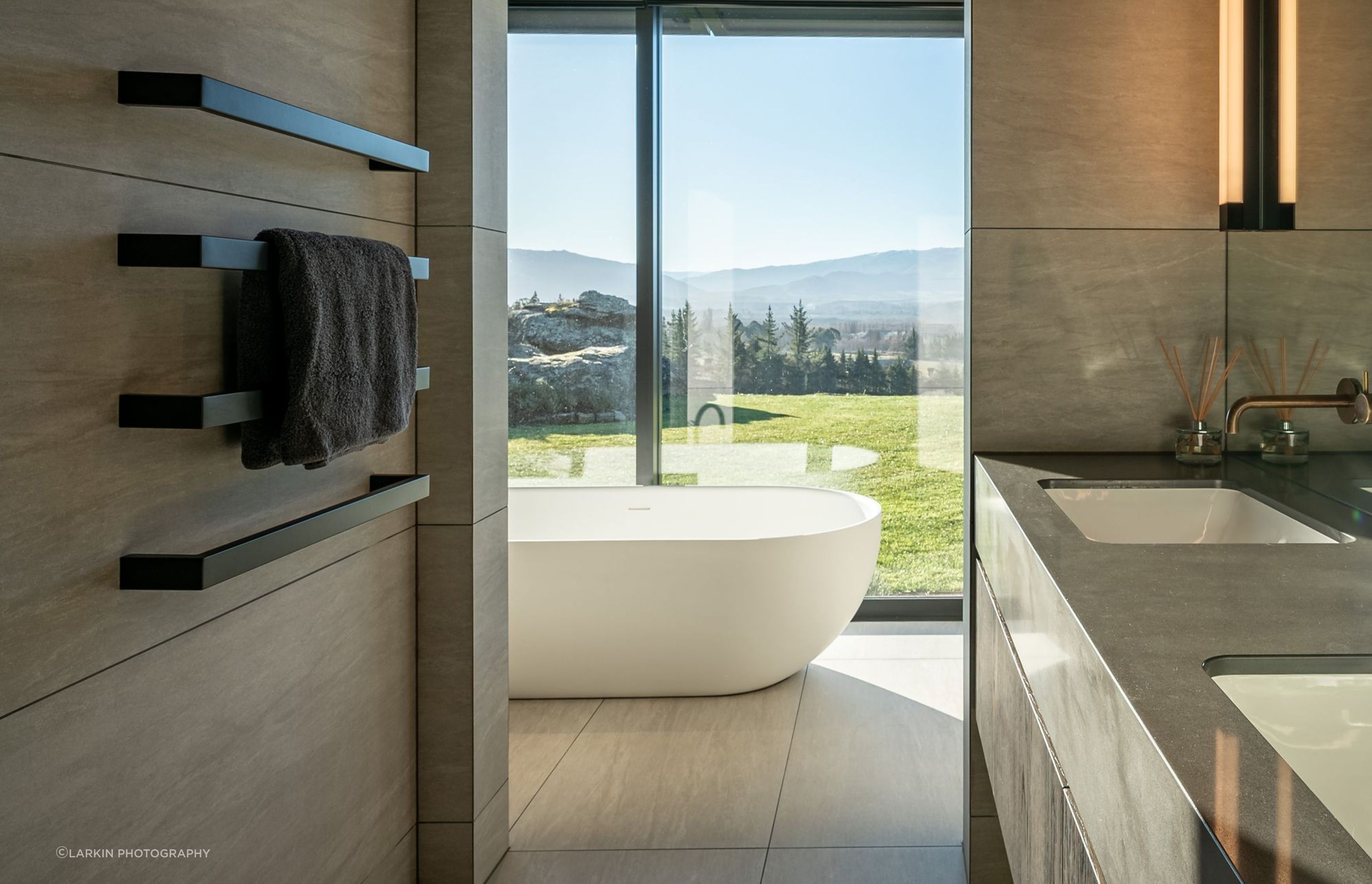 The master suite's freestanding bath enjoys an idyllic view to the lawn and views beyond.