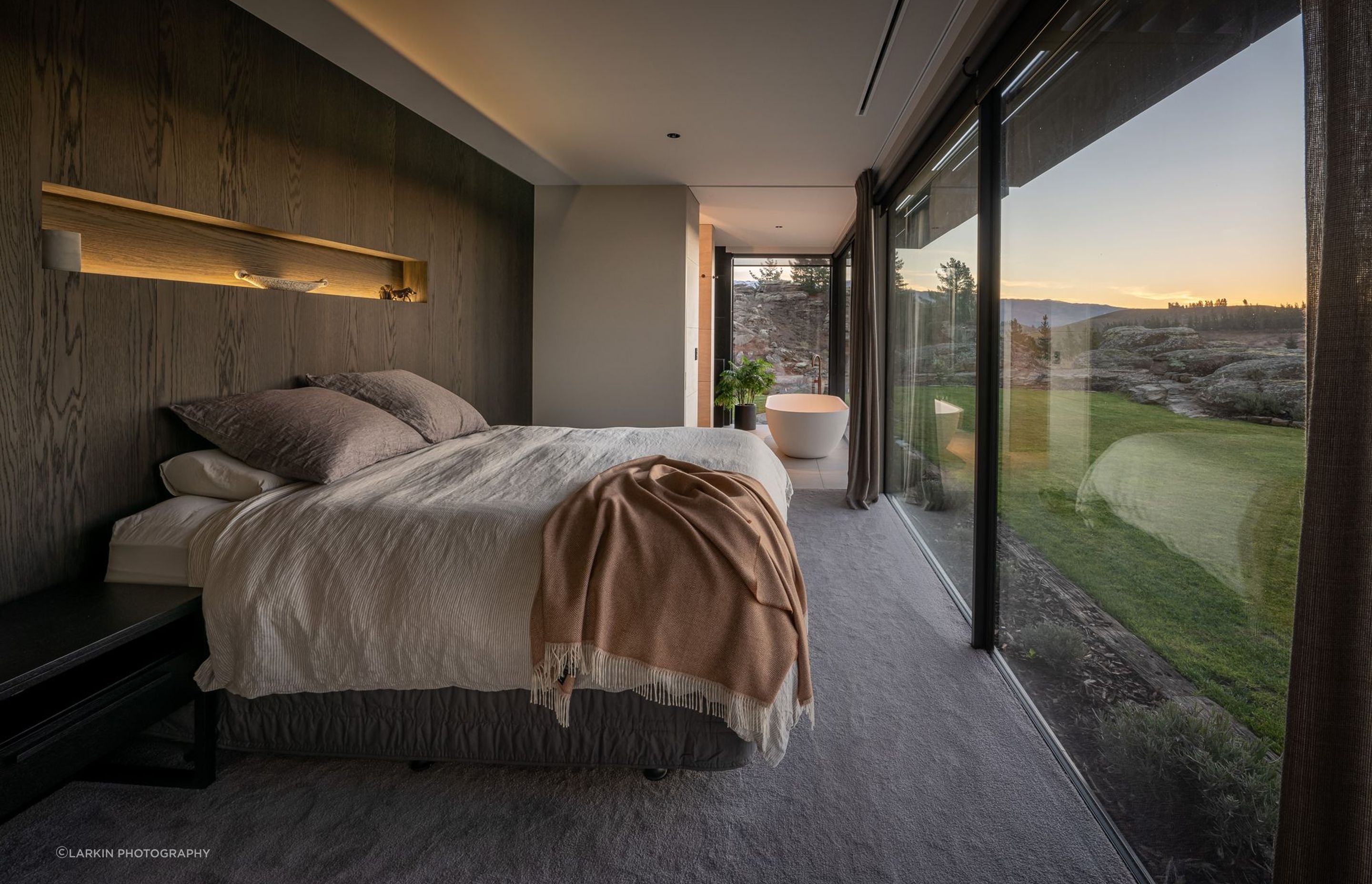 The master bedroom enjoys uninterrupted views through floor-to-ceiling glazing.