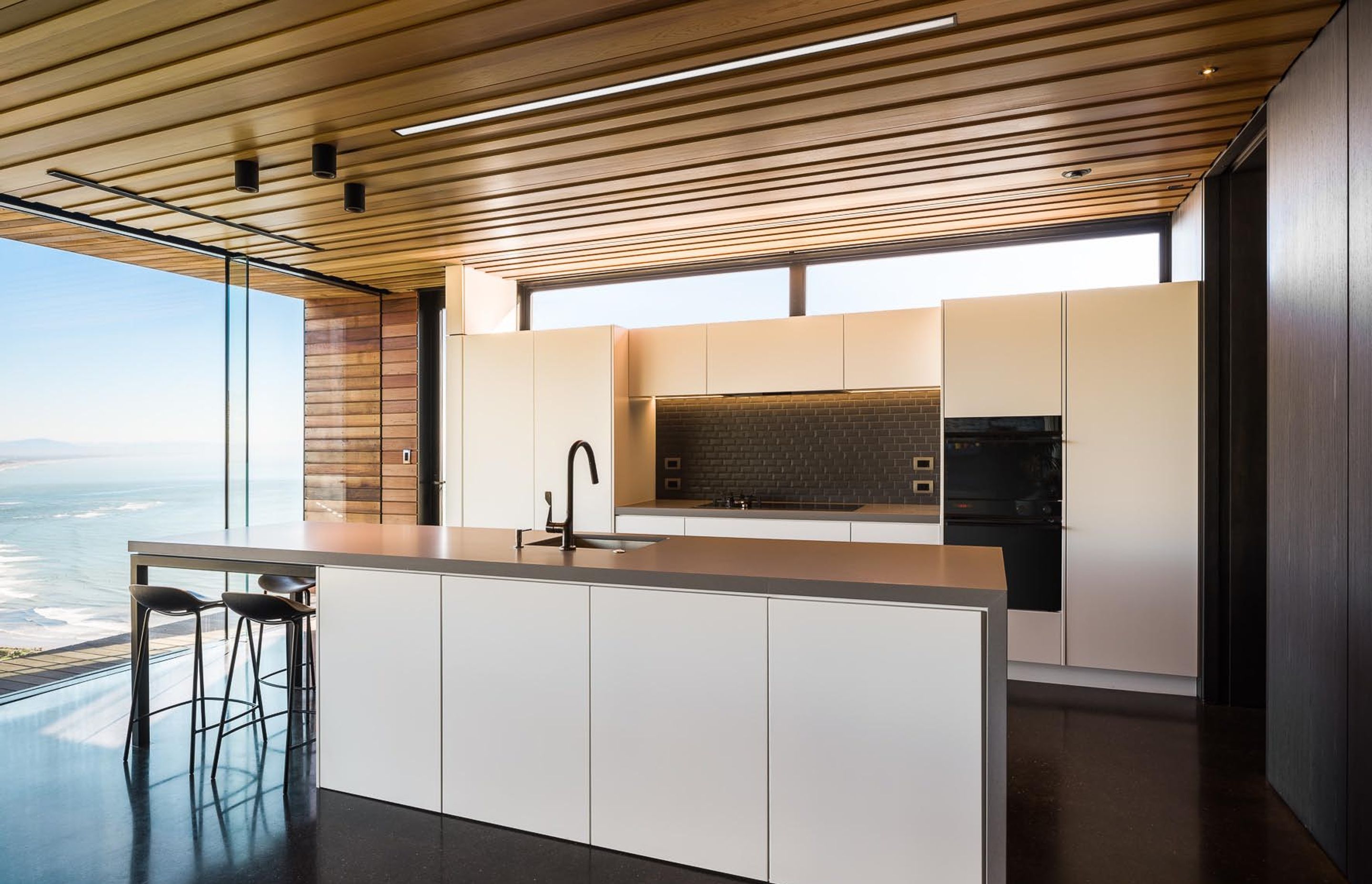 A monochromatic colour palette in the kitchen allows the view to take centre stage.