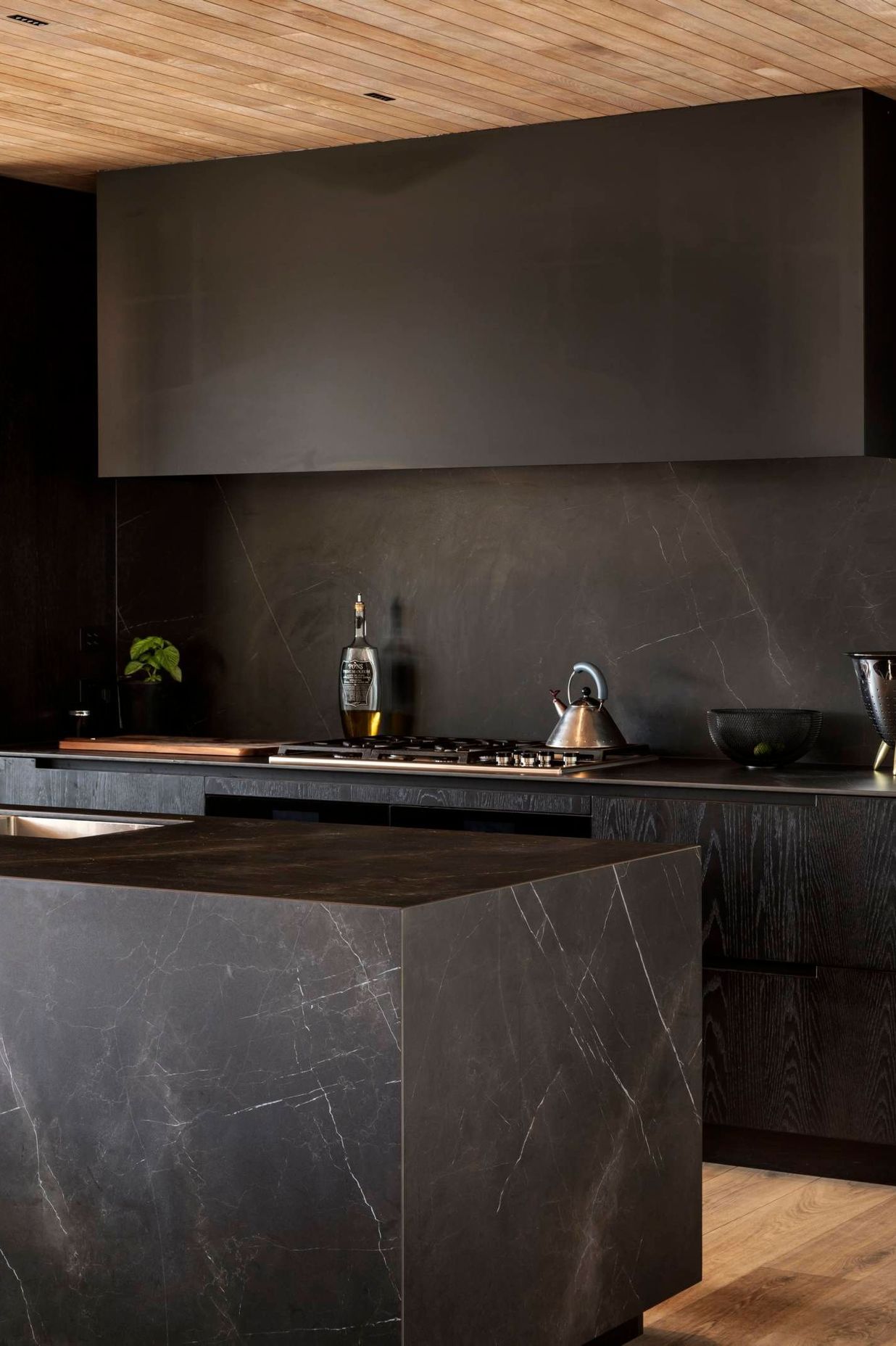 Kitchen designer Morgan Cronin set up a moody textural feel for the kitchen through tone-on-tone marble-effect porcelain and darkly stained oak.
