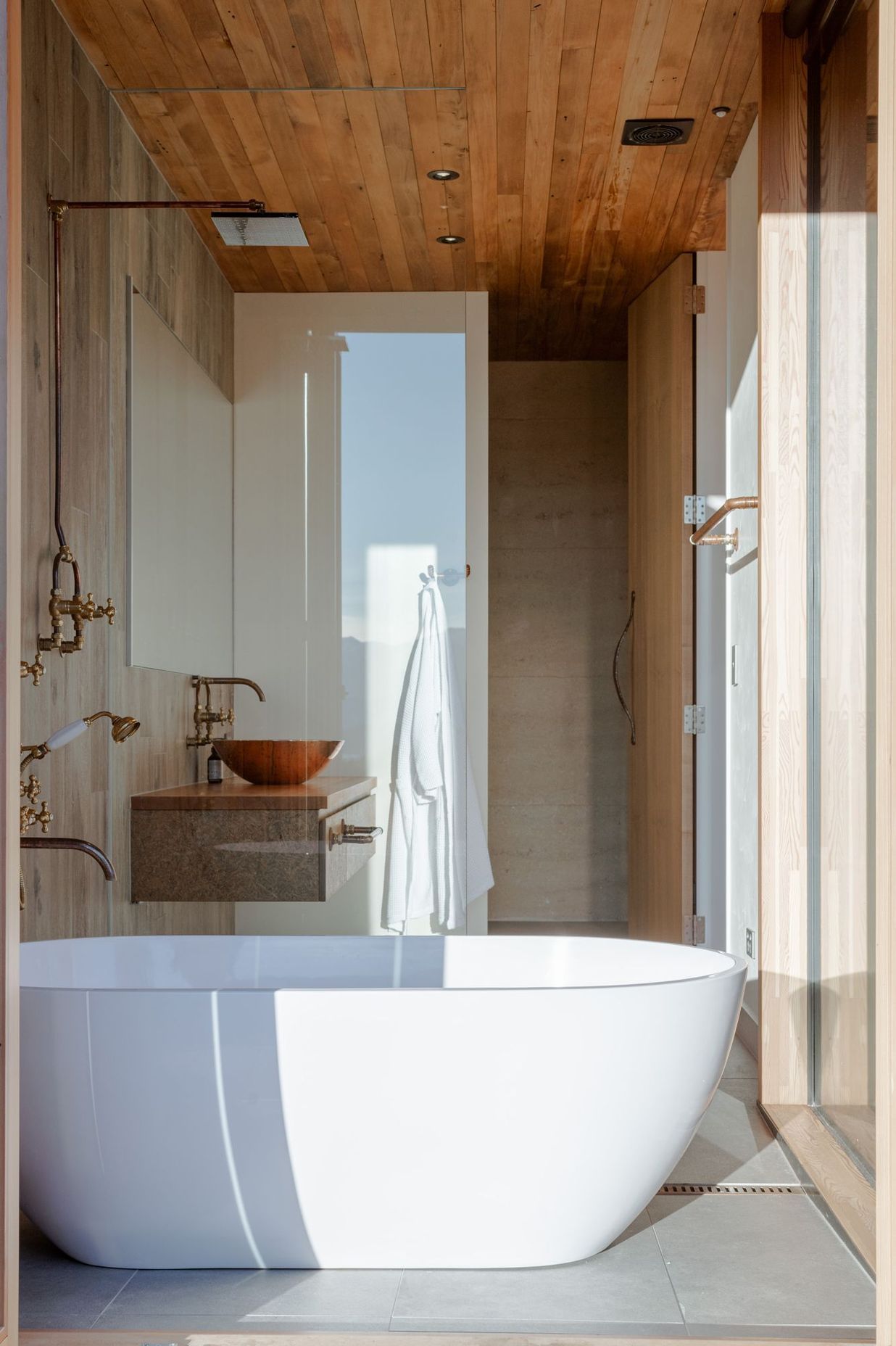 The free-standing bath sits within its own enclave with bifolding doors that open directly to the deck.