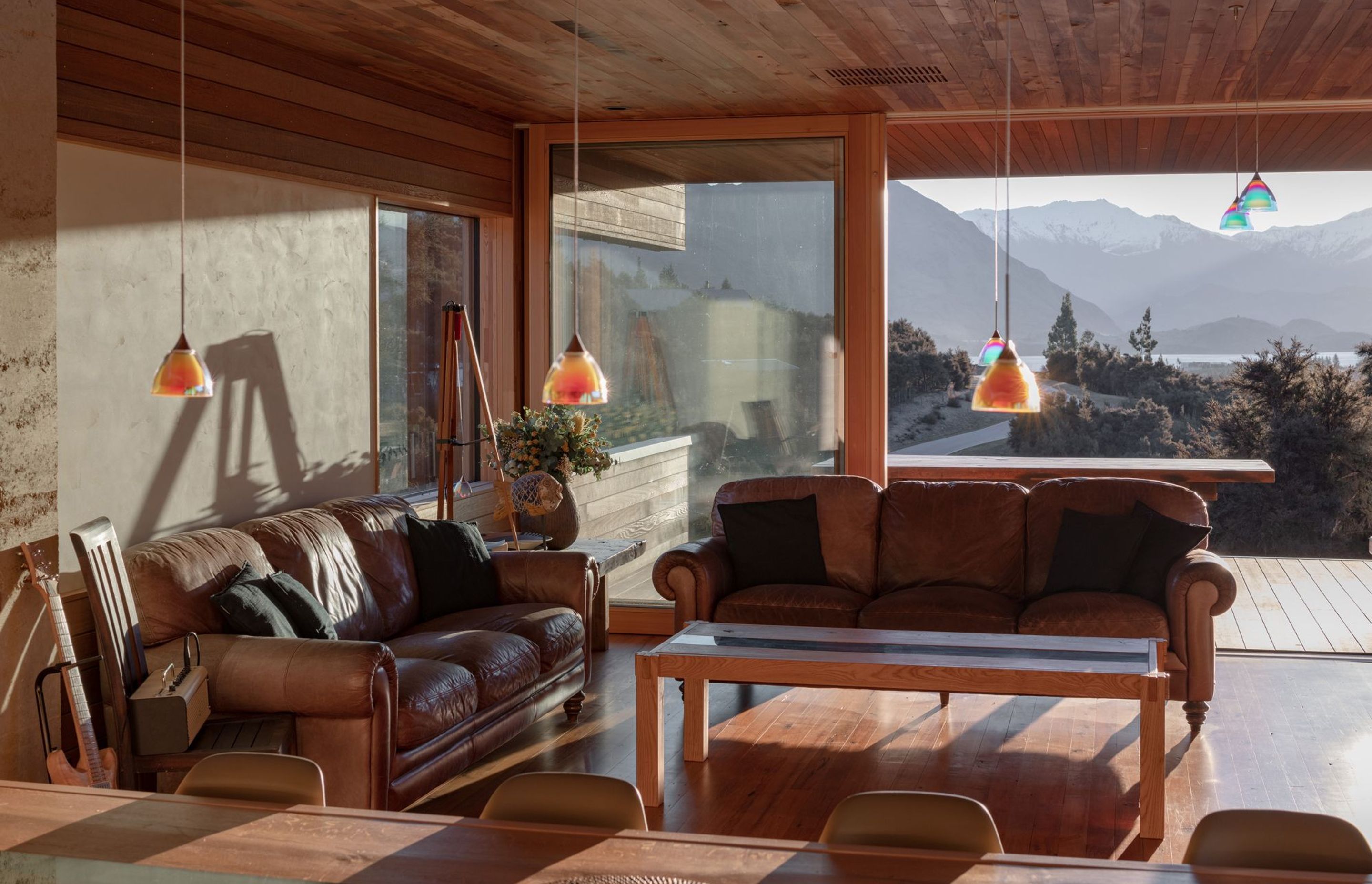 Large, triple-glazed doors in recycled Siberian larch joinery help moderate the internal temperature while maintaining access to the lake and mountain views.