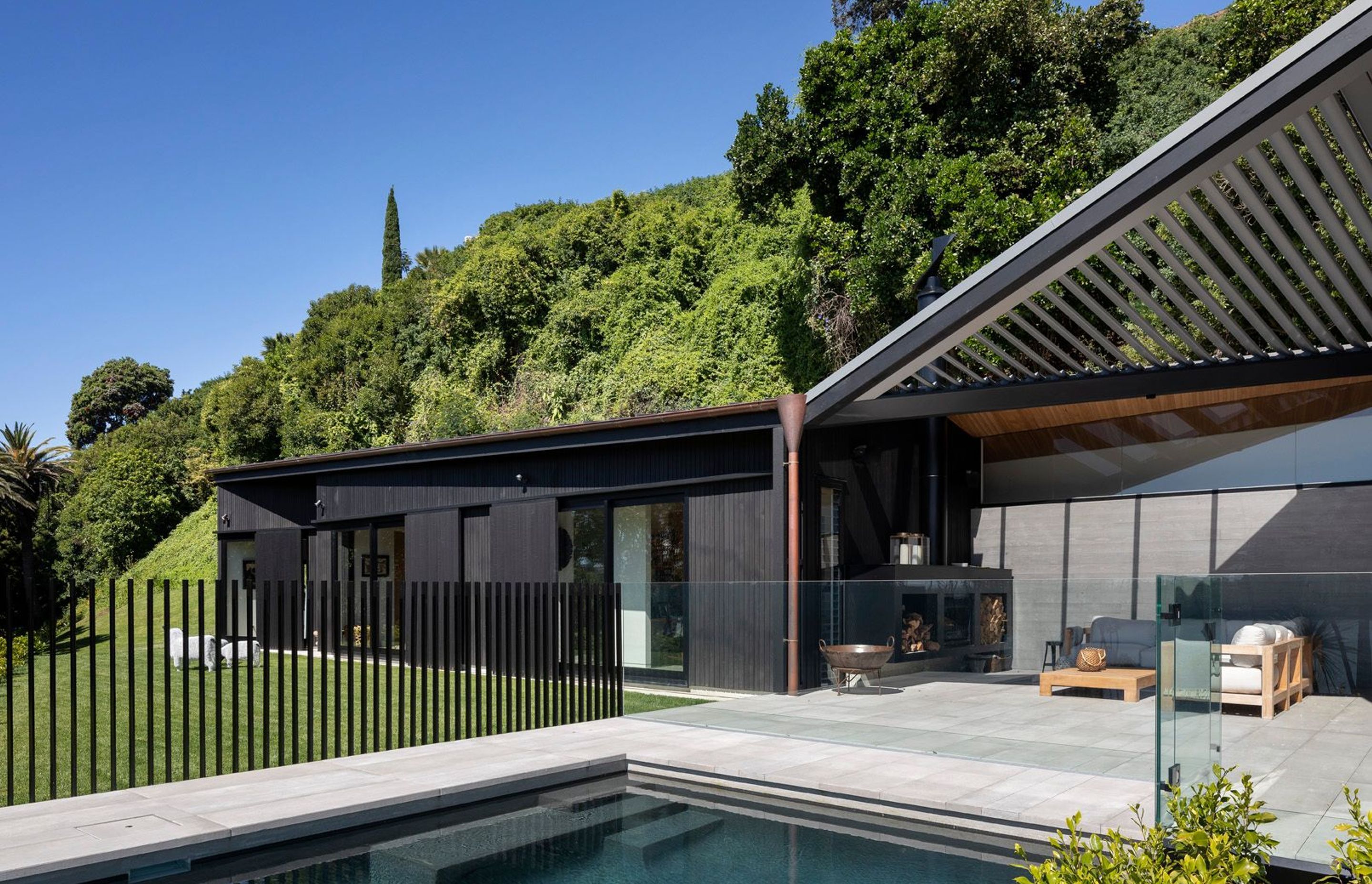 A single-storey form—which contains a family room and guest bedrooms—pulls away from the main house allowing for the insertion of a glazed and louvered outdoor room, centred on the swimming pool.