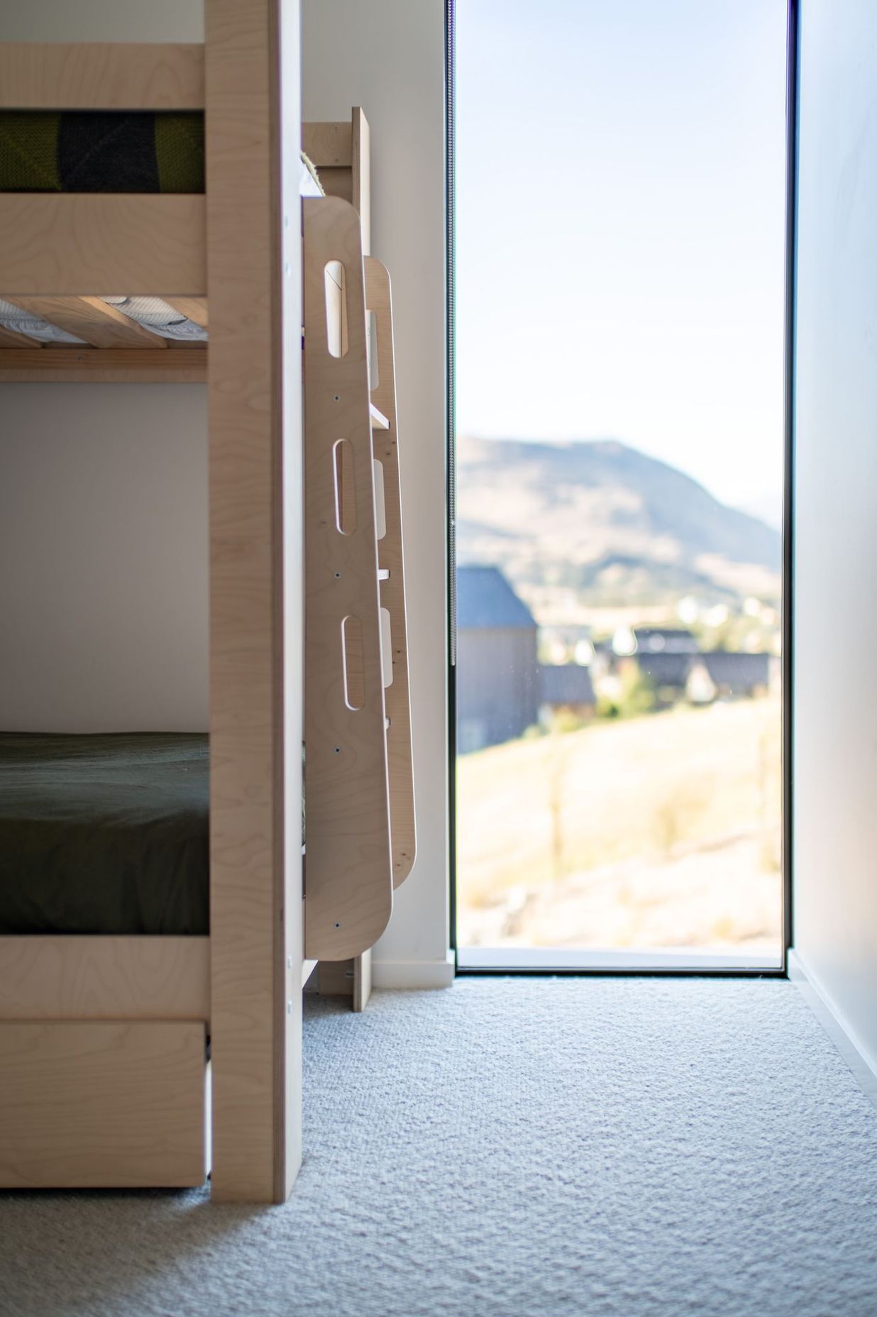 A child's bedroom features a slot window to take in light and scenery.