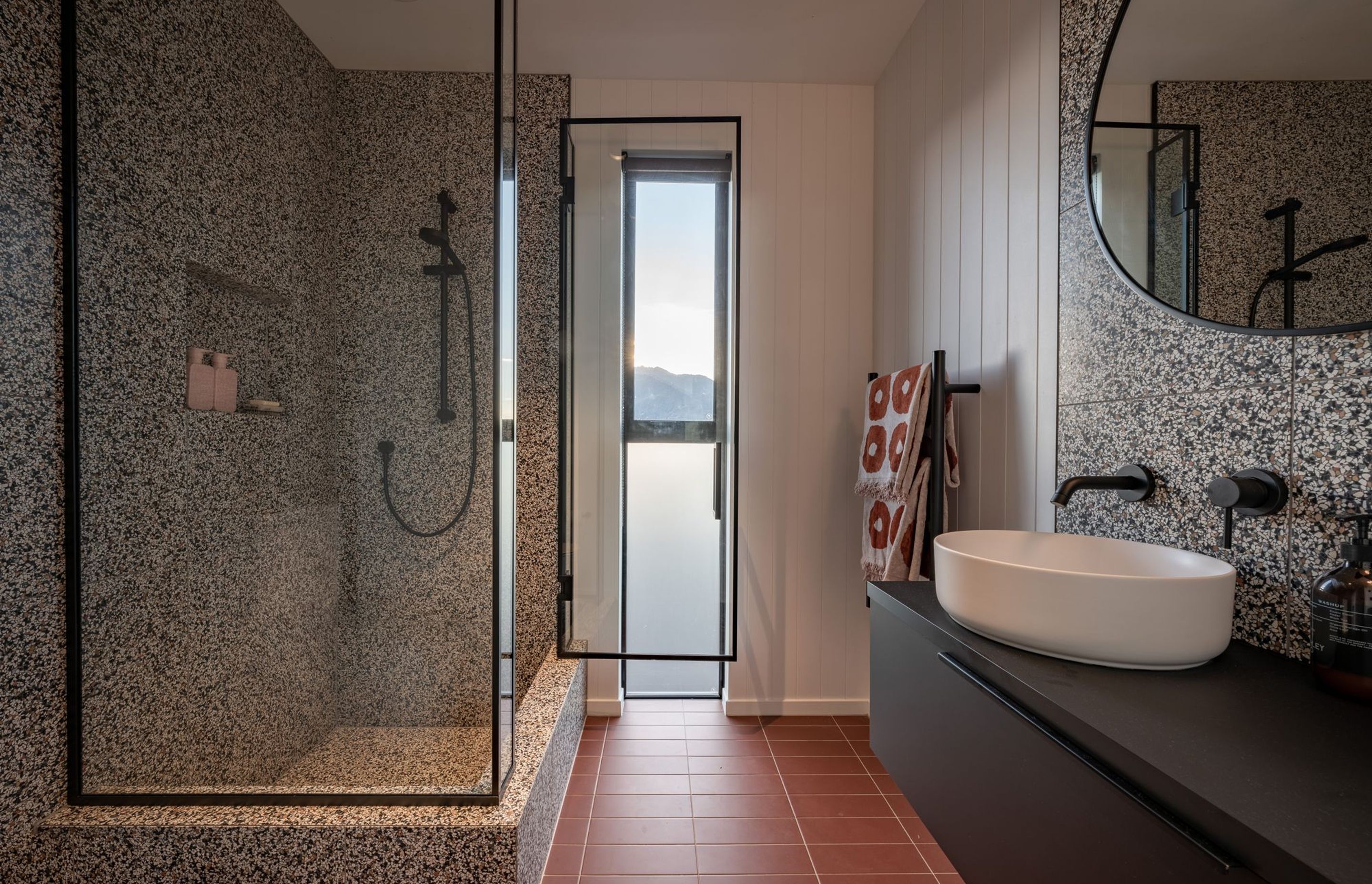 The family bathroom is far more playful, with terracotta floors, and speckled tiles, with a shub built into the shower.