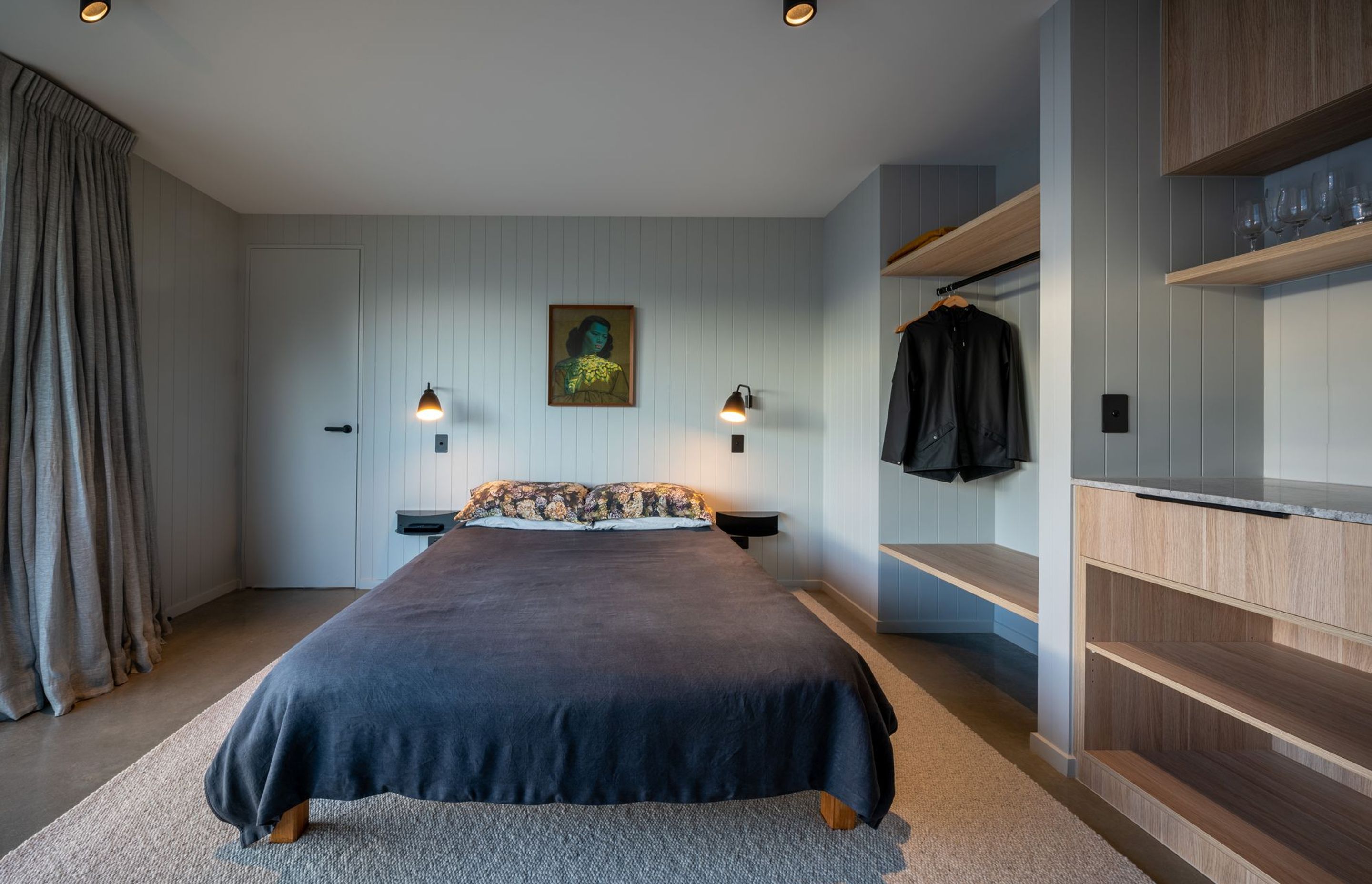 Each bedroom uses a different soft hue on the grooved walls to express the space.