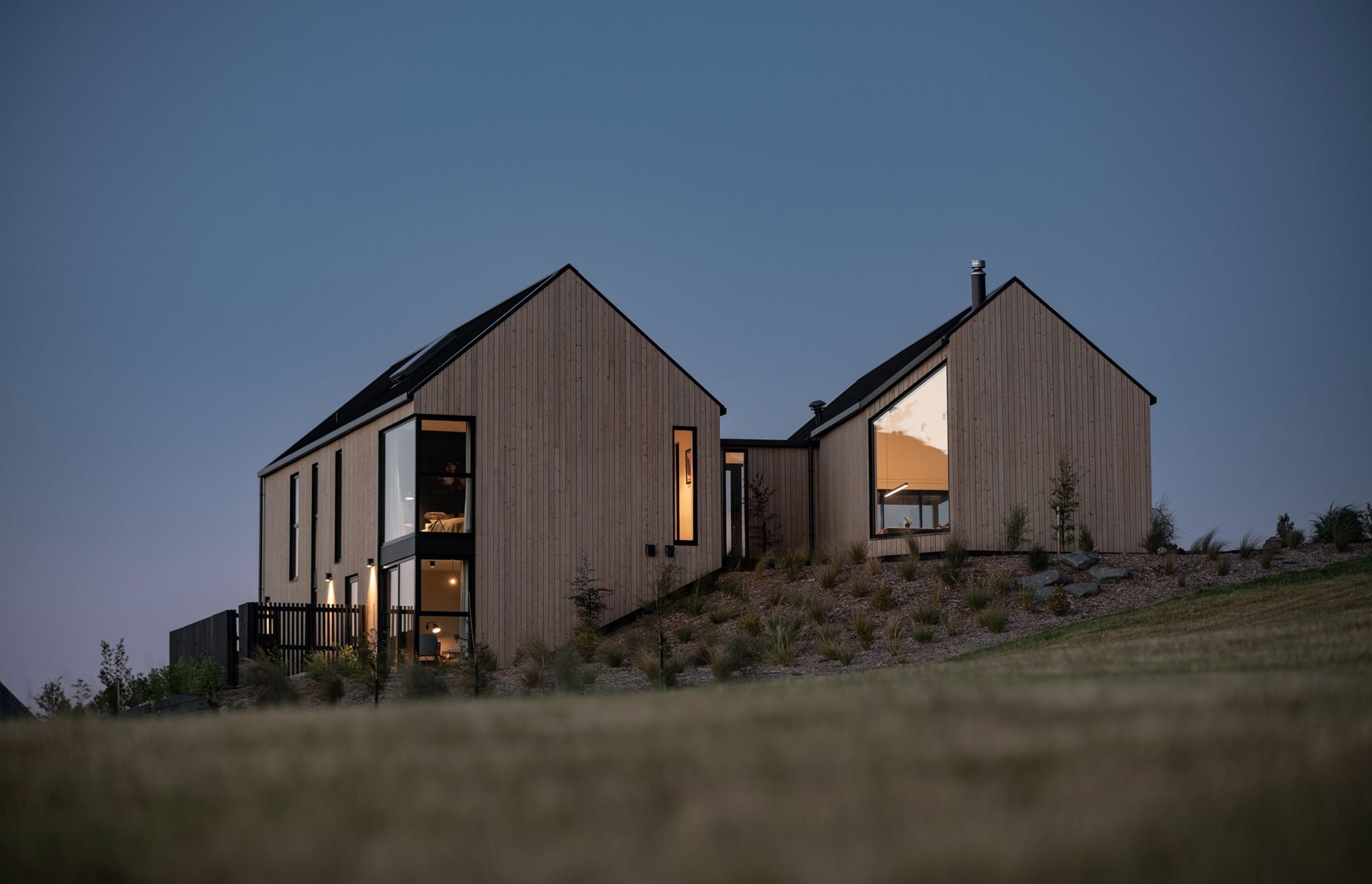 At dusk, the home takes on the same hues as the landscape.