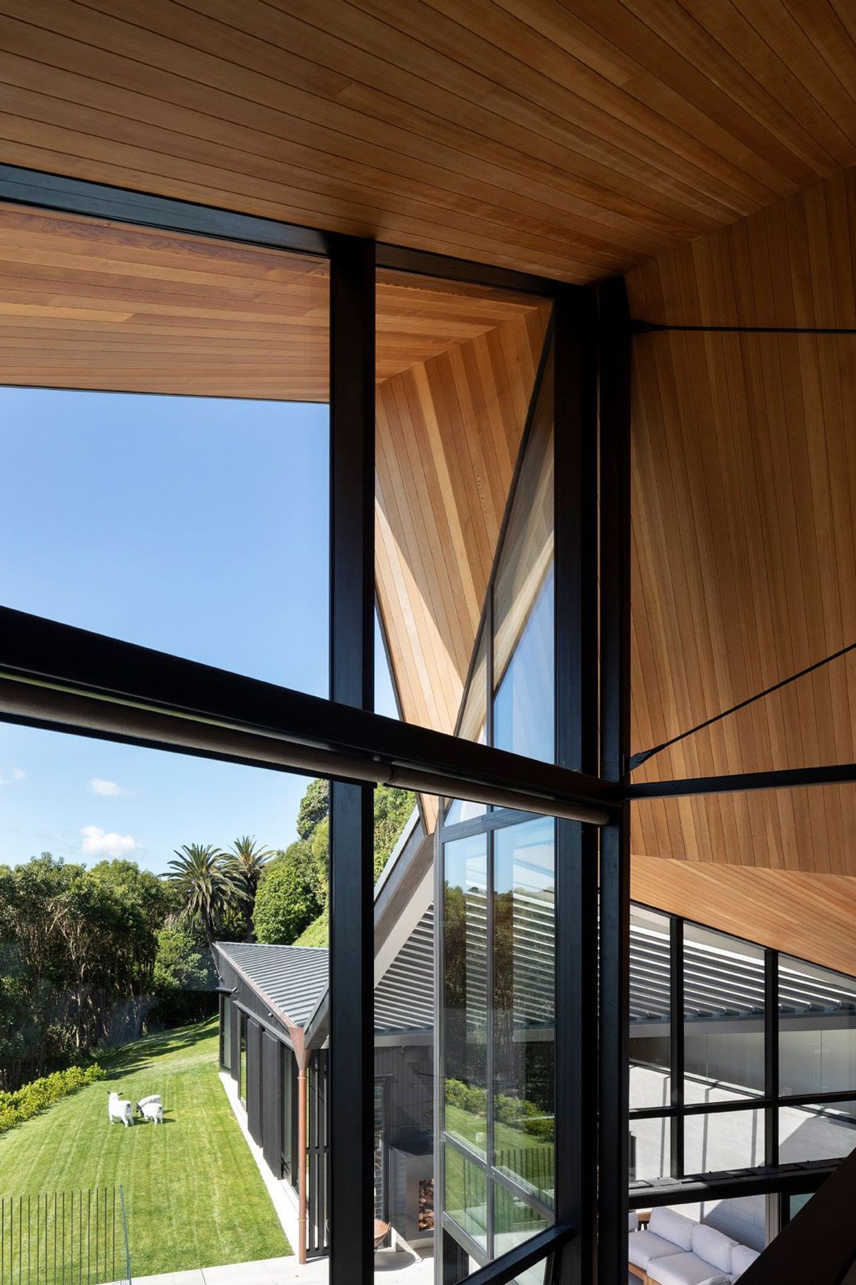 From the mezzanine main bedroom, the roof form is a big gesture, in the scale of the cliff, embracing the house and defined by the folds of the faceted ceiling.
